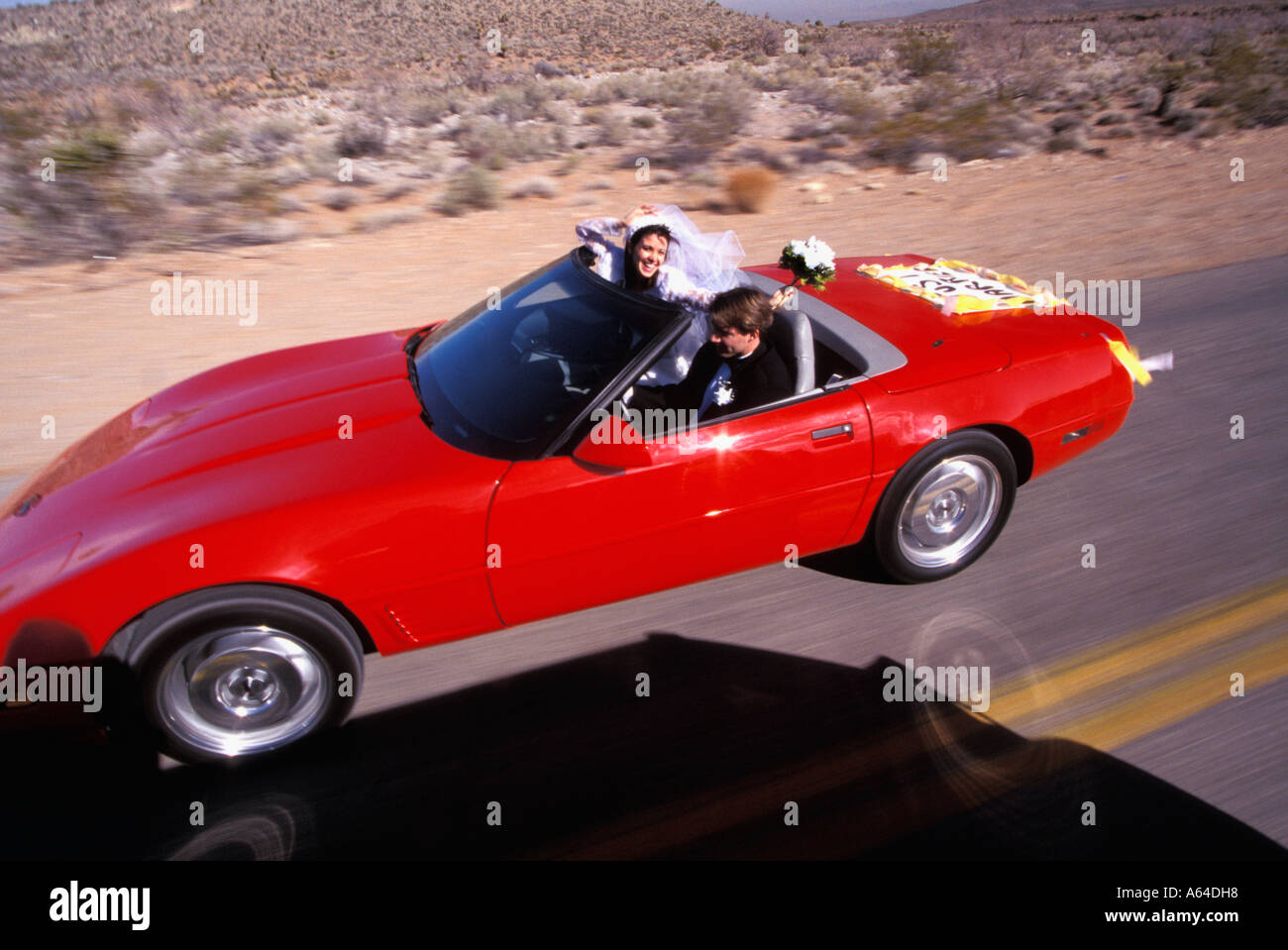Mariée et le Marié à travers les roches rouges du désert l'autoroute près de Las Vegas NEVADA USA Banque D'Images