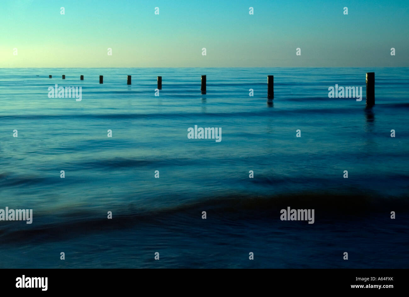 Posts allant dans la mer à l'aube Banque D'Images