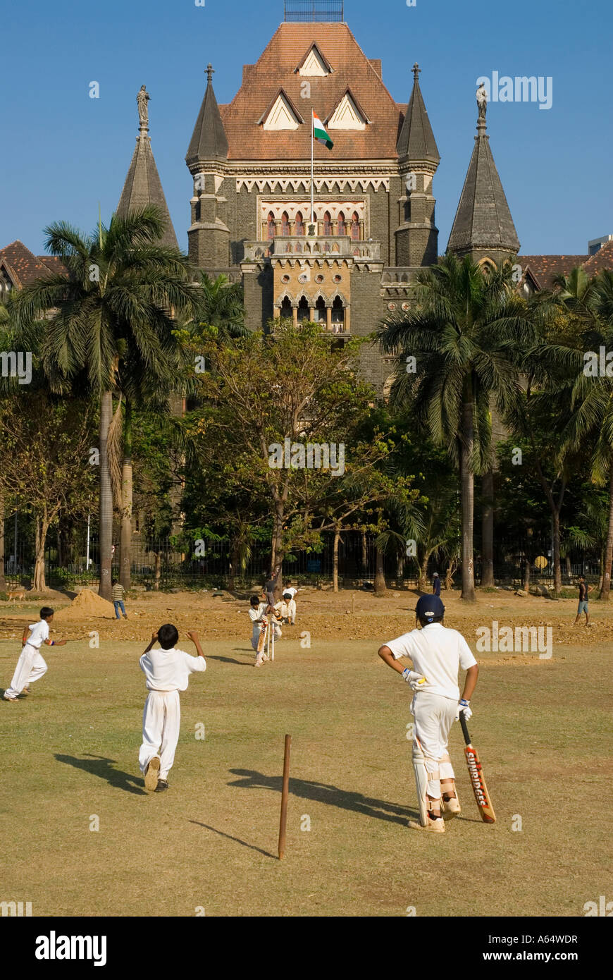 Les gens à jouer au cricket à l'Oval Maiden avec le palais de justice dans le contexte de l'Inde Mumbai Banque D'Images