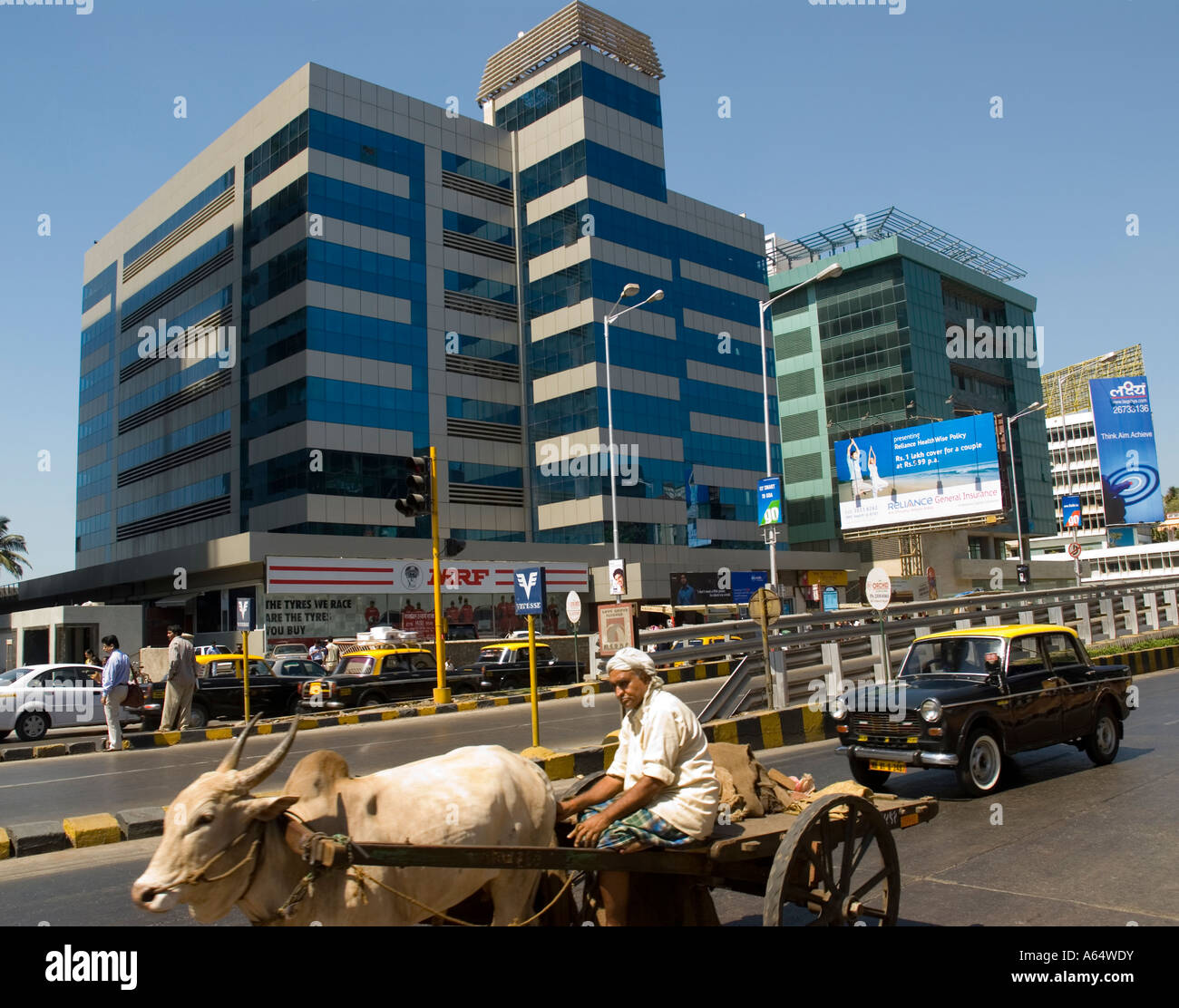 Ouvrier manuel sur un bœuf tiré panier passant l'évolution moderne des bureaux Mumbai Inde Banque D'Images