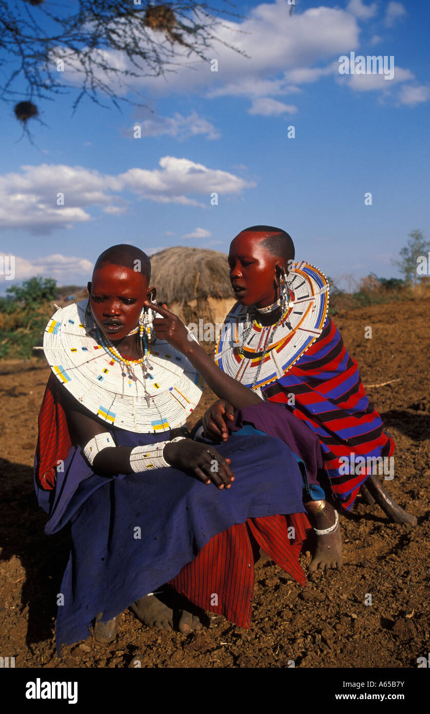Les femmes masaï peindre leurs visages d'ocre rouge en préparation d'une cérémonie Longido Tanzanie Banque D'Images