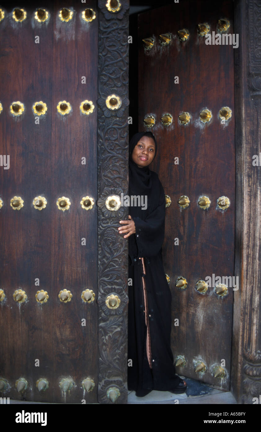 Femme portant un traditionnel Swahili bui bui debout dans une porte de Zanzibar Zanzibar Tanzanie Banque D'Images