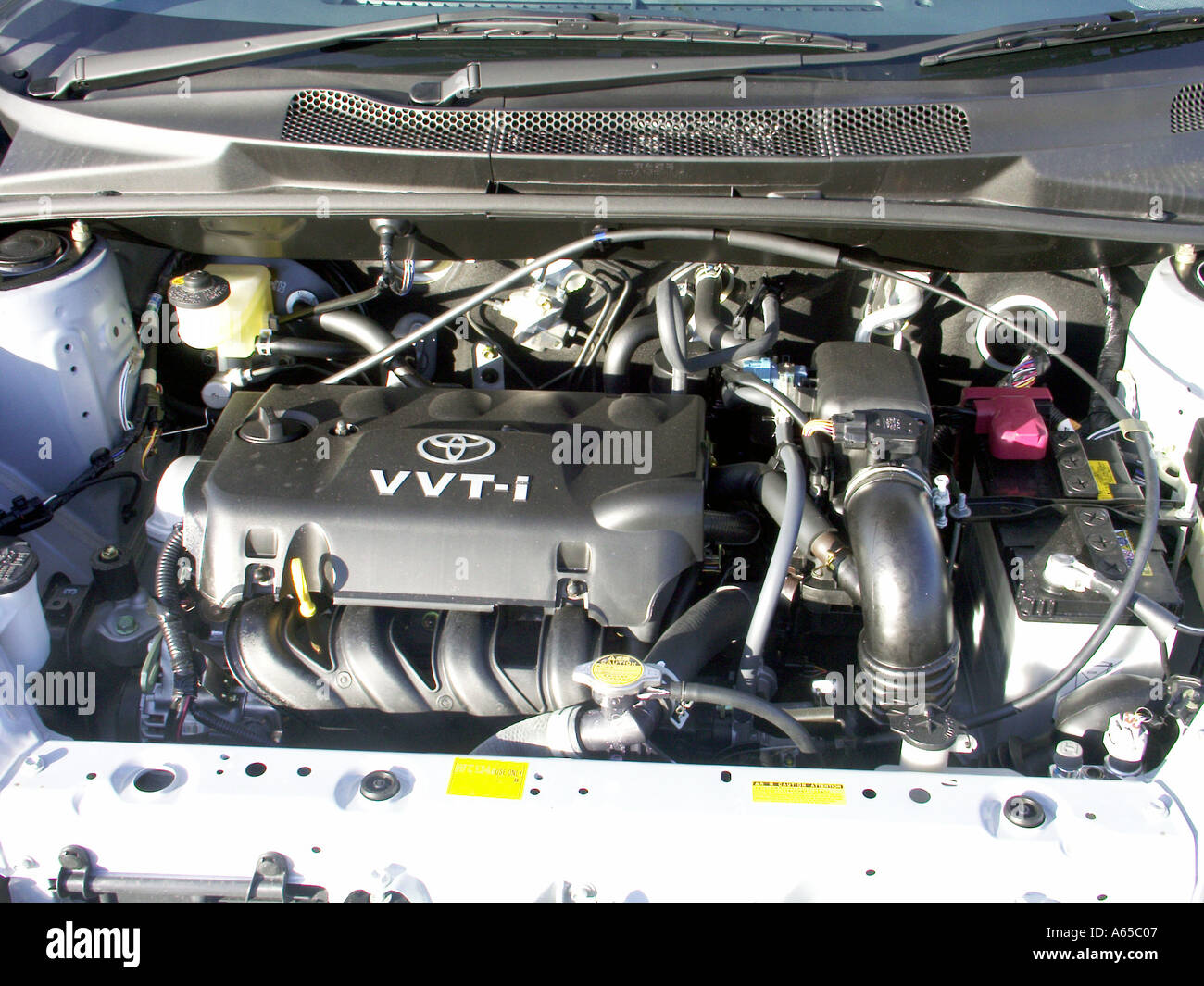 Toyota Yaris essence voiture VVT-i moteur gros plan composants du compartiment moteur fabriqués en série sous le capot vue avec capot relevé Essex Angleterre royaume-uni Banque D'Images