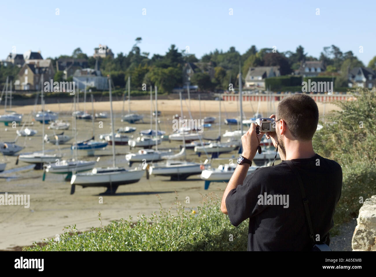 L'HOMME À PRENDRE DES PHOTOS DE BATEAUX À MARÉE BASSE SAINT-BRIAC-SUR-MER COVE BRETAGNE FRANCE Banque D'Images