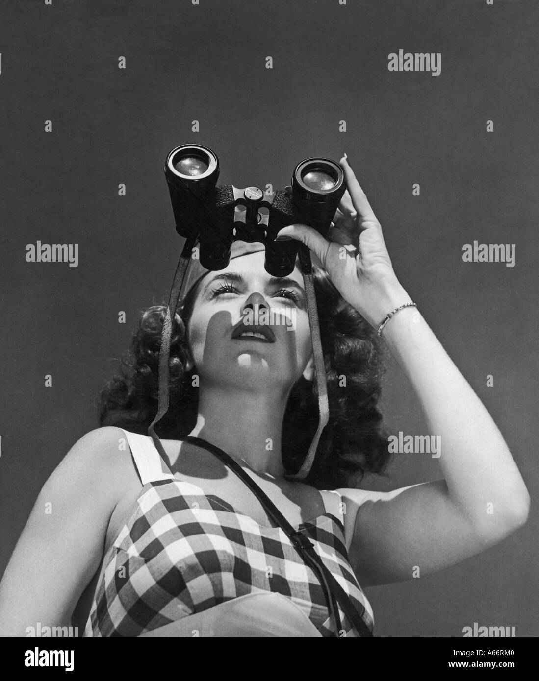 Femme avec des jumelles Banque D'Images