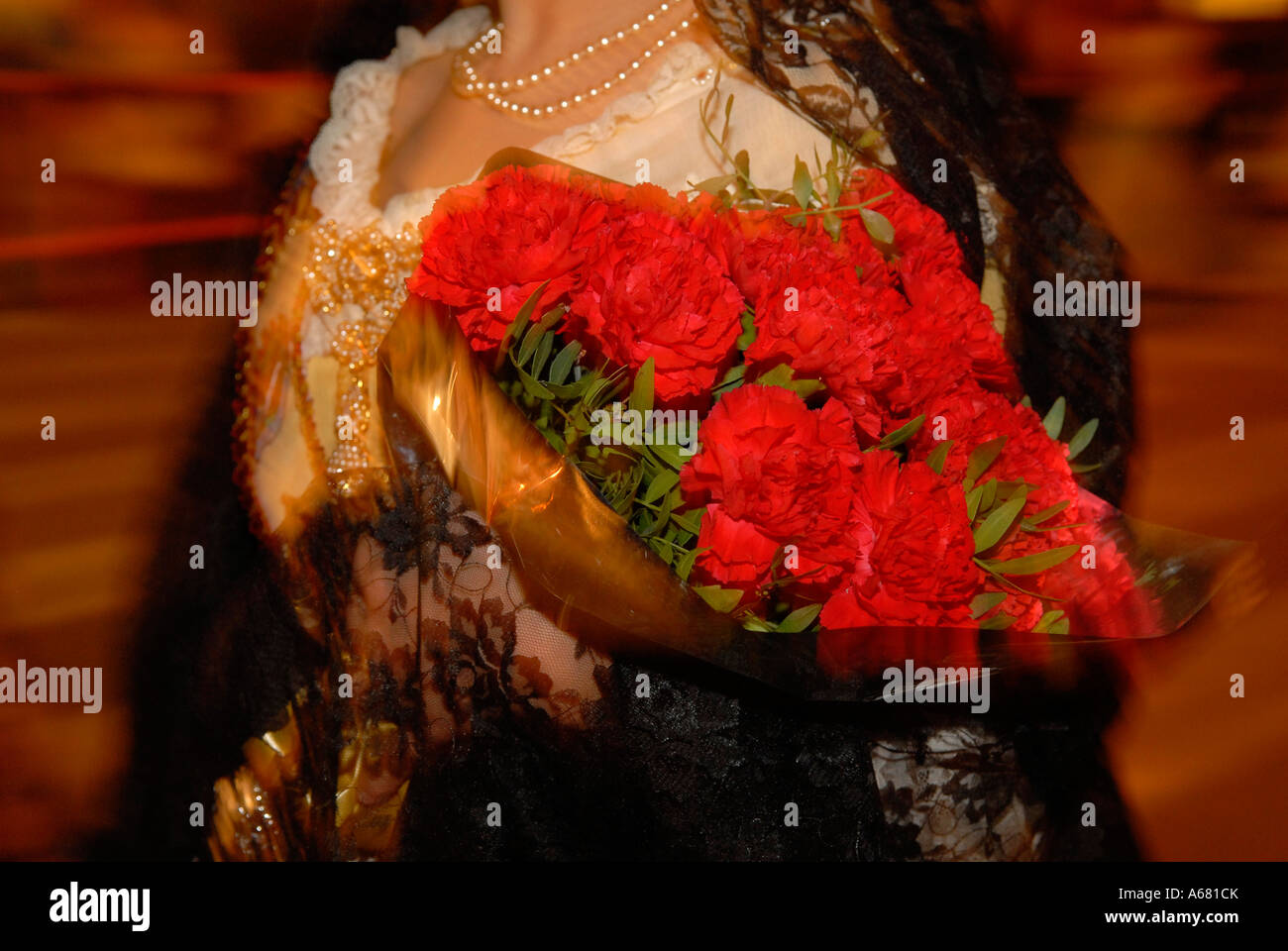 Reveler en costume traditionnel holding bouquet de fleurs rose rouge au cours de Fallas de Valence Espagne Banque D'Images