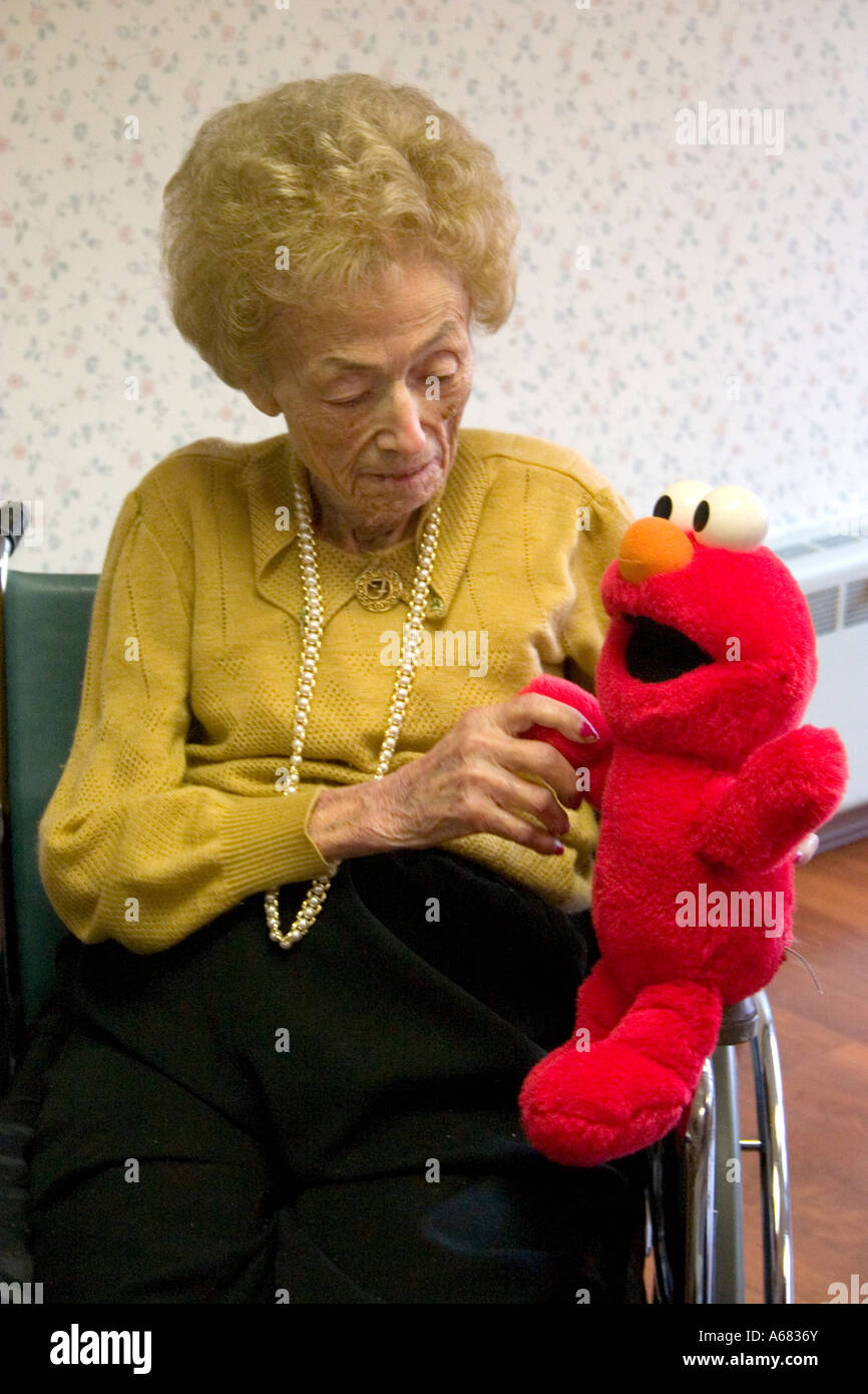 Hauts Femme Âge 94 tenant une Tickle Me Elmo jouet pour enfants. Maison de retraite maçonnique du Minnesota Burnsville Minnesota USA Banque D'Images