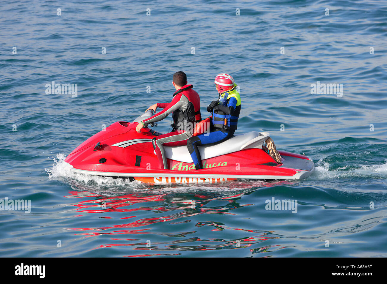 Jeune couple d'une grande circonscription jetbike rouge sur la mer ou l'océan Banque D'Images