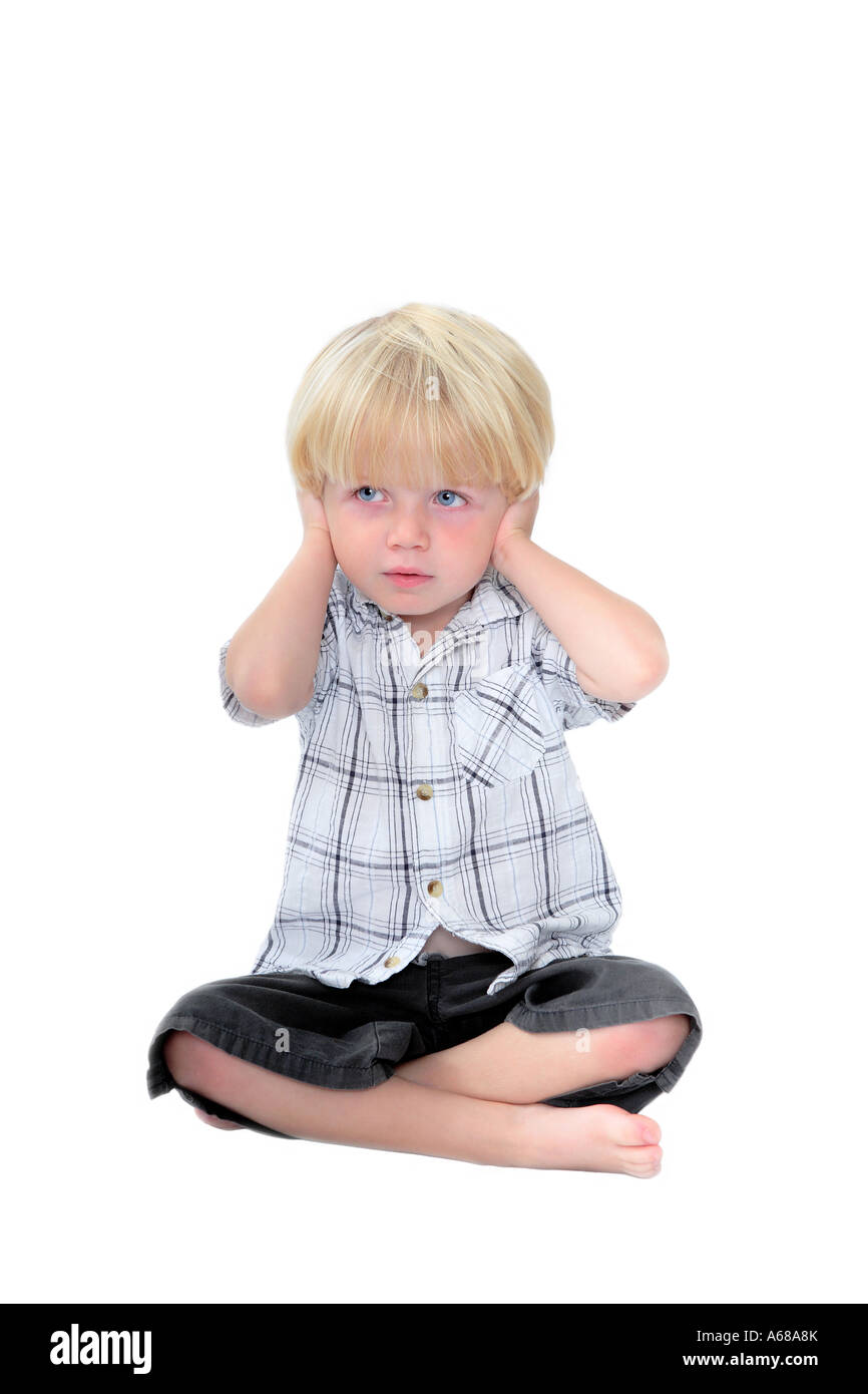 Studio photo de jeune garçon avec ses mains sur ses oreilles et blanc fond isolé Banque D'Images