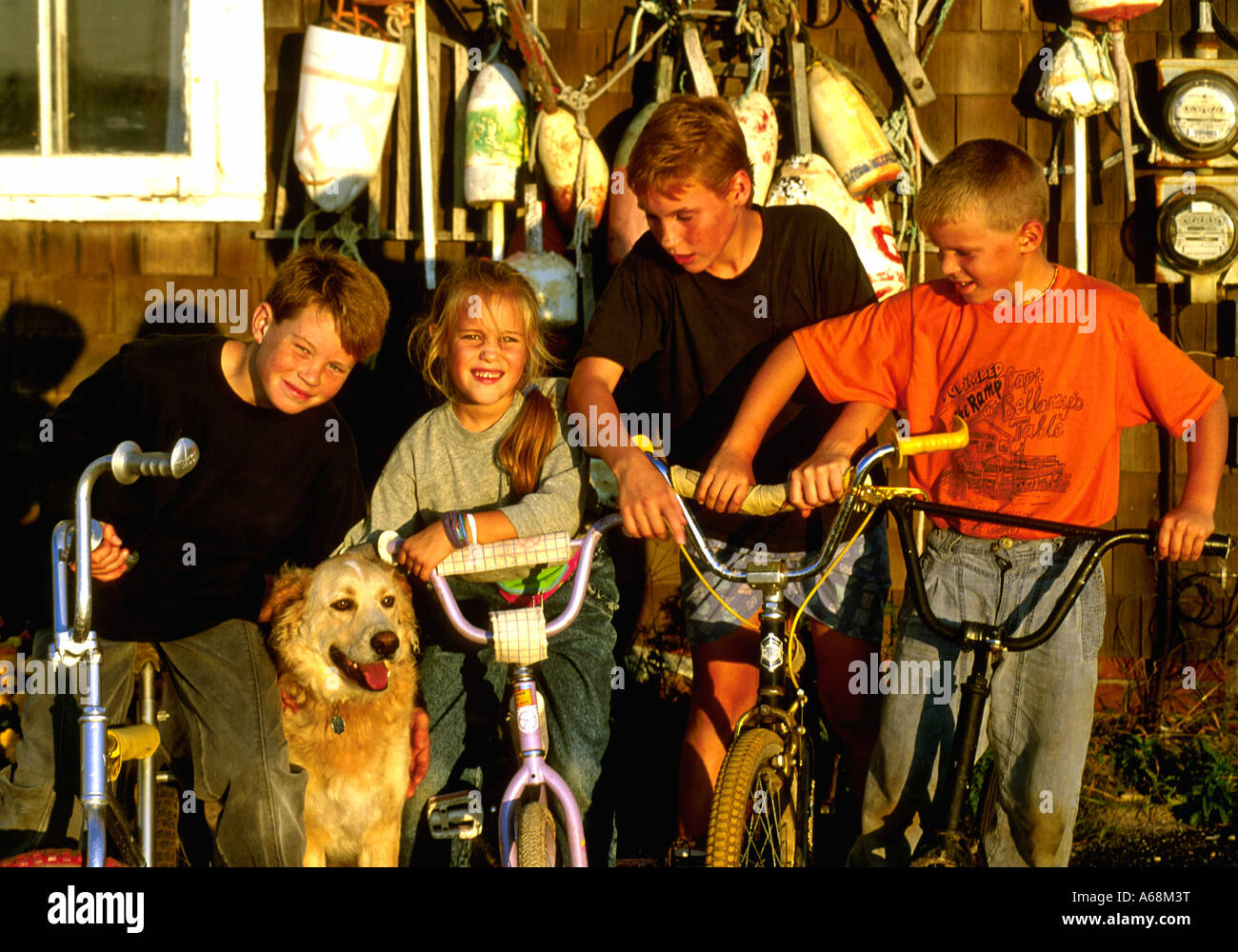 Groupe d'enfants sur des vélos avec chien Banque D'Images
