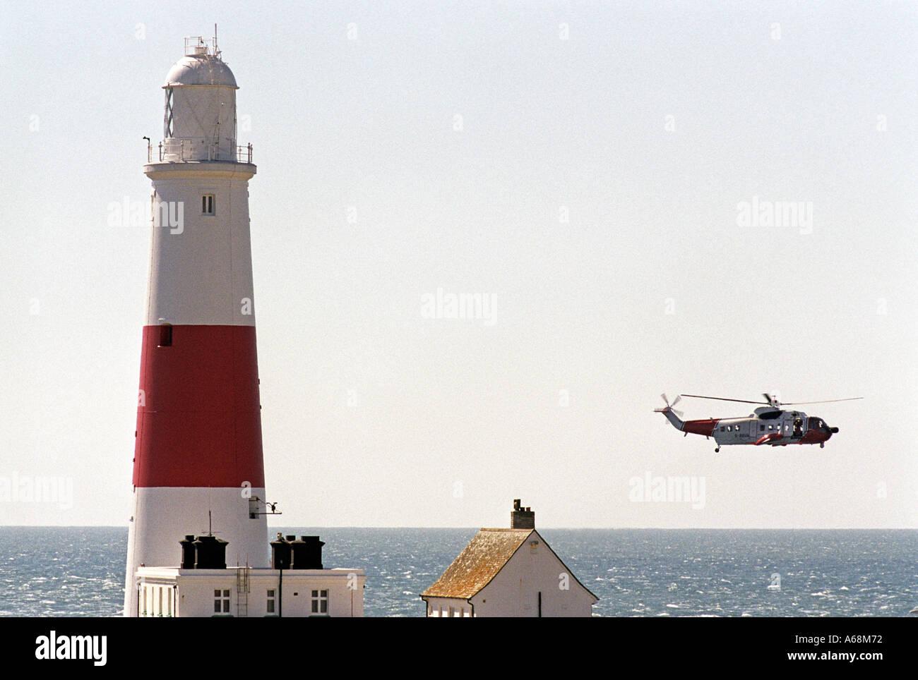Un hélicoptère de sauvetage de la Garde côtière par vol Portland Bill lighthouse à Portland, dans le Dorset UK Grande-Bretagne Banque D'Images