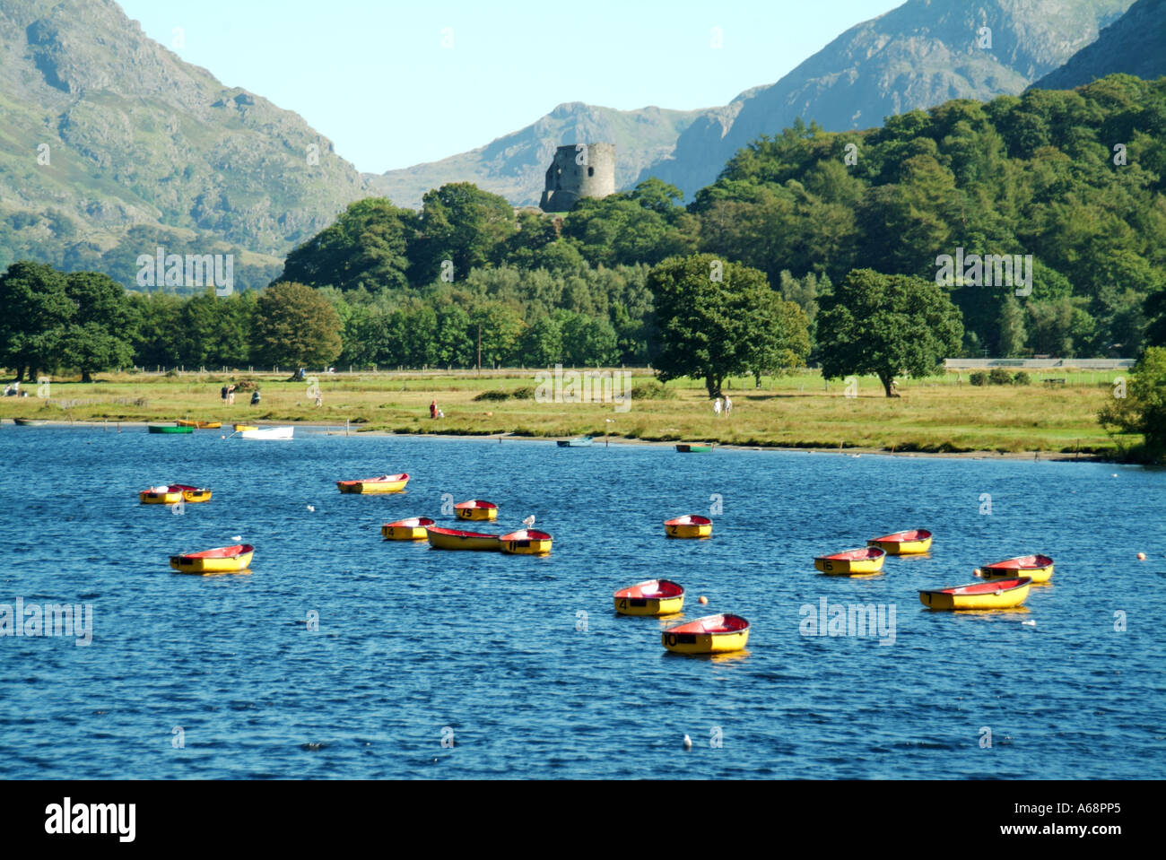 Llyn Padarn moraine glaciaire formé un barrage sur le lac avec barques et tour en ruine du château de Dolbadarn à Llanberis Gwynedd Snowdonia North Wales UK Banque D'Images