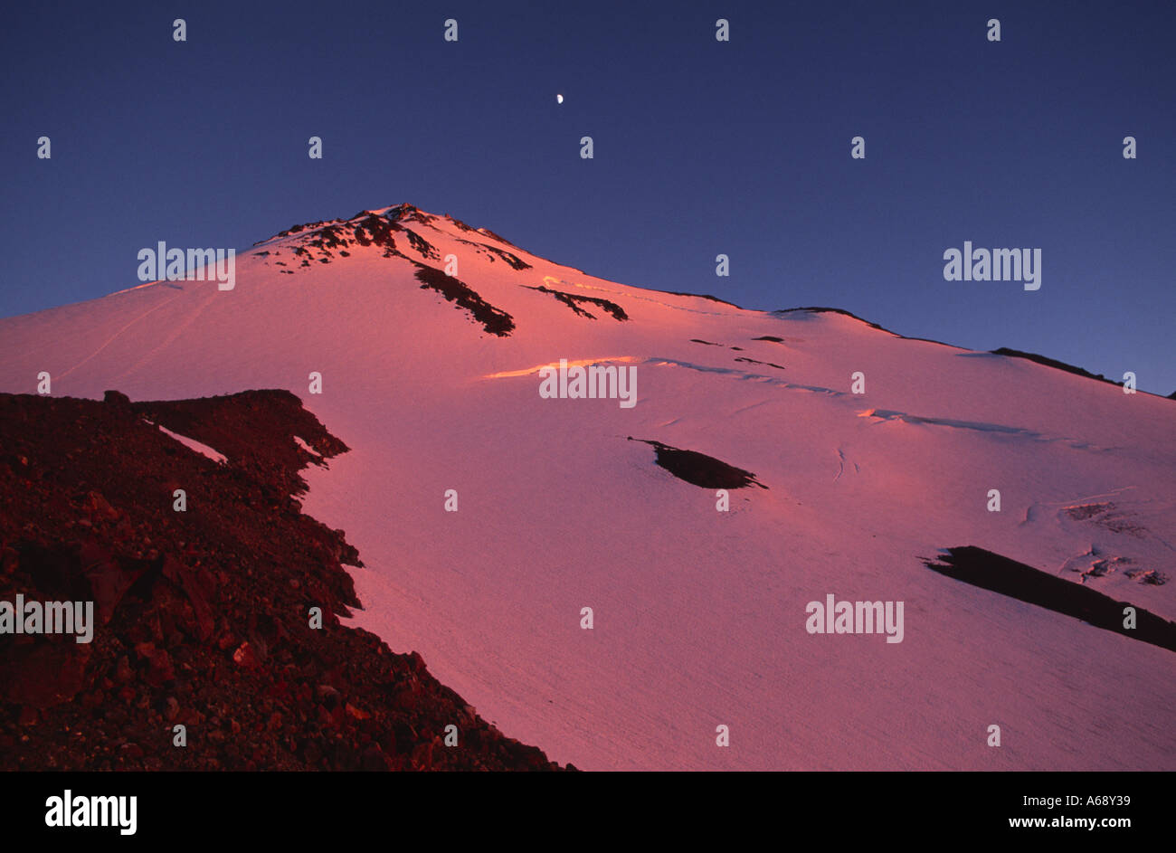 Coucher du soleil jette une teinte orange rosâtre sur le côté nord du Mont Shasta, Californie USA Banque D'Images