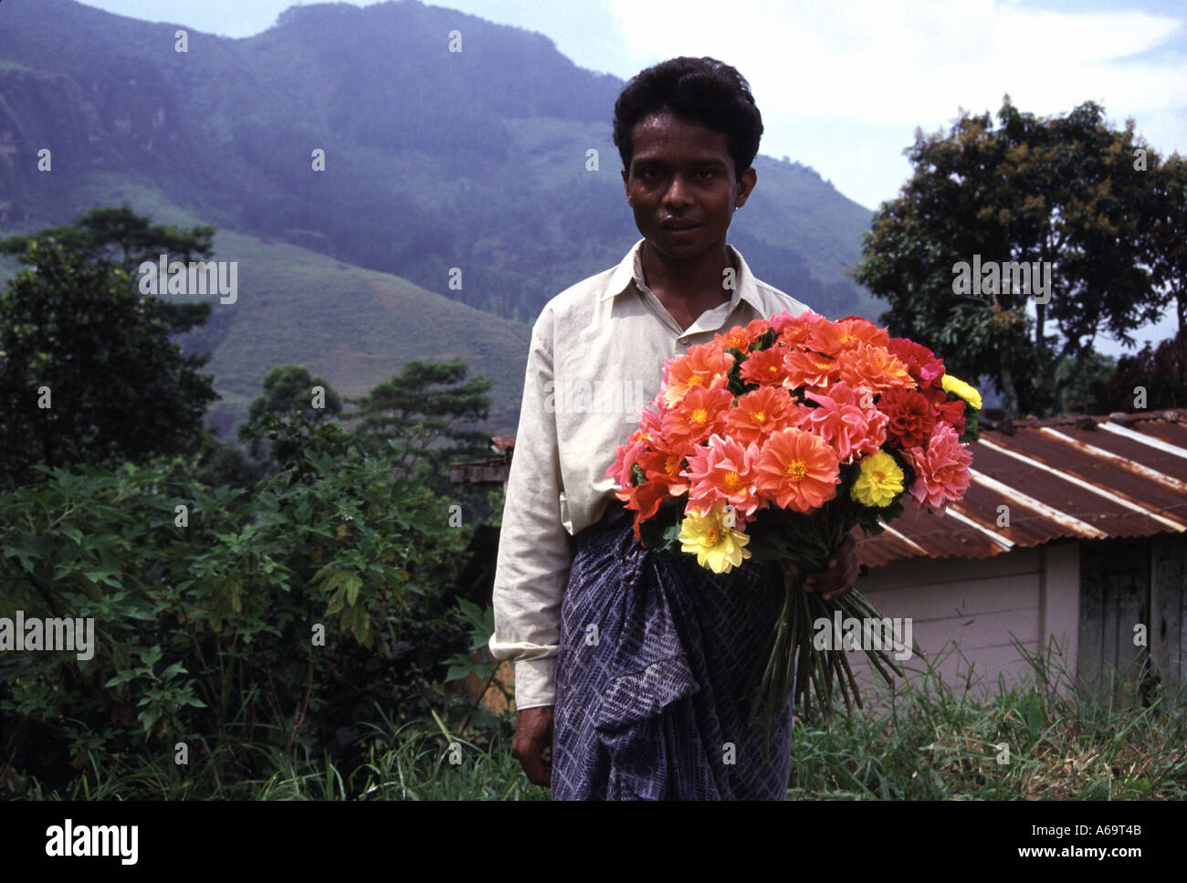 Homme tenant un bouquet de fleurs orange et jaune au Sri Lanka Banque D'Images