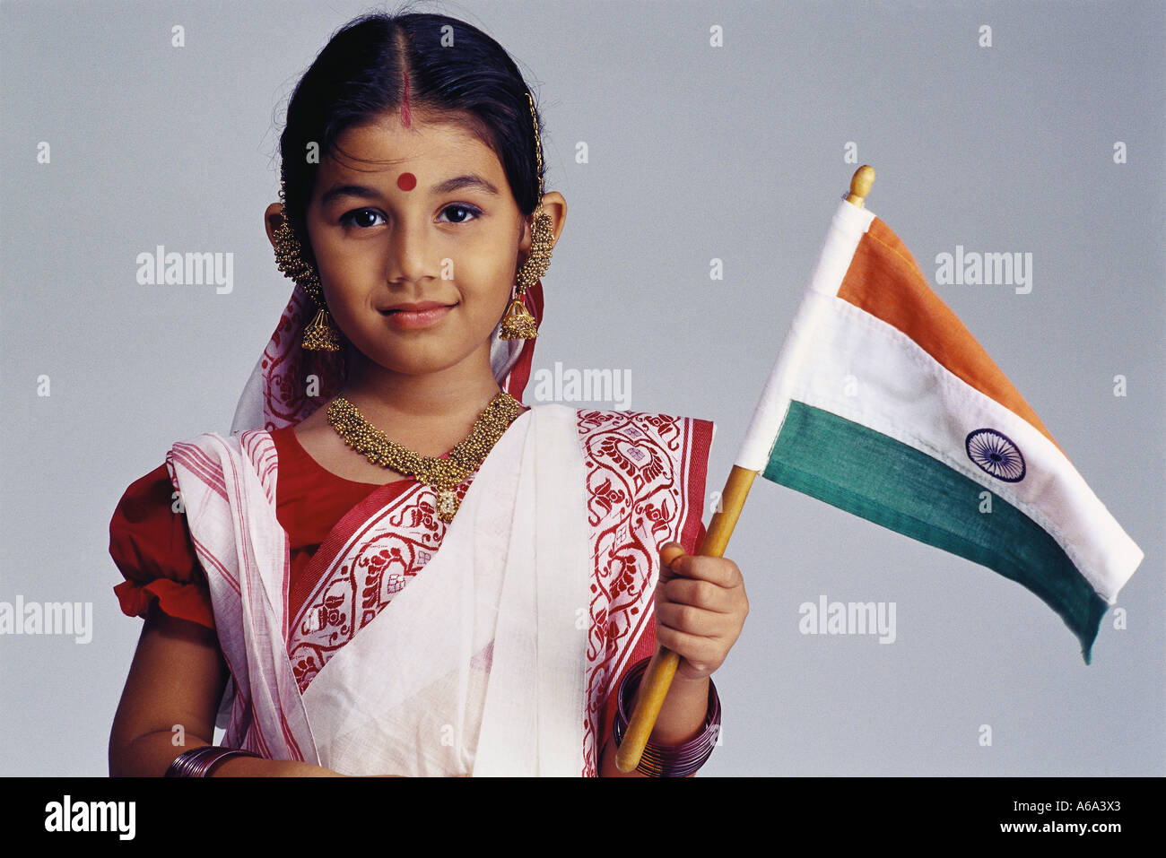 Bengali indien girl Waving Flag de l'Inde portant sari traditionnel bindi point sur le front de l'Asie de l'Inde Numéro 501 Parution du modèle Banque D'Images