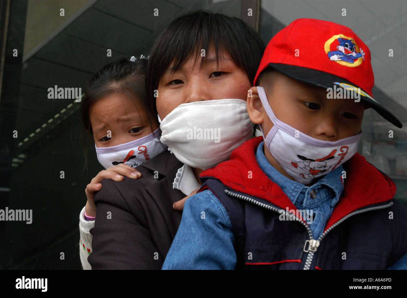 Une femme migrante et son fils et sa fille tous les masques d'attendre à quitter Pékin après le SRAS Banque D'Images