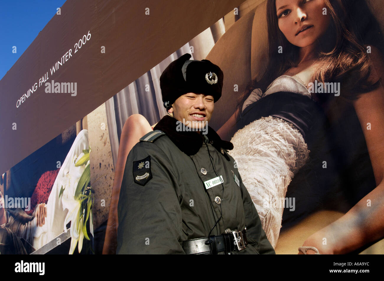 Un garde de sécurité se trouve en face d'un billboard Gucci à Beijing, Chine. 14 déc 2005 Banque D'Images