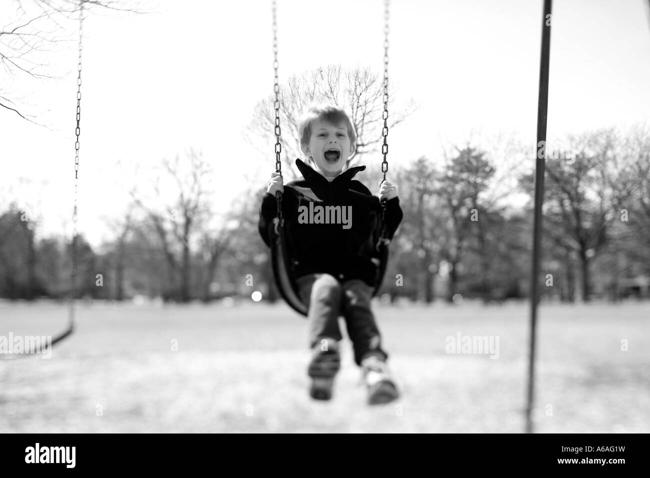 Petit enfant sur une balançoire de rire et sourire Banque D'Images Petit enfant sur une balançoire de rire et sourire Banque D'Images
