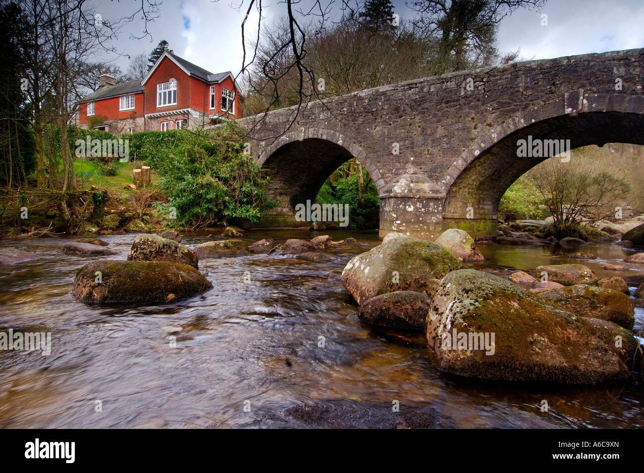 Rivière Dart coule sous le pont du chemin de pierre à Dartmeet sur South Devon Dartmoor Banque D'Images