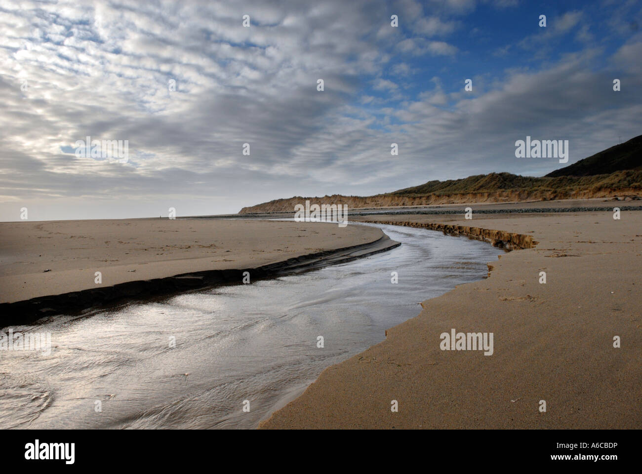 Une rivière d'eau de mer circulant dans la plage à Aberdovey au Pays de Galles Banque D'Images