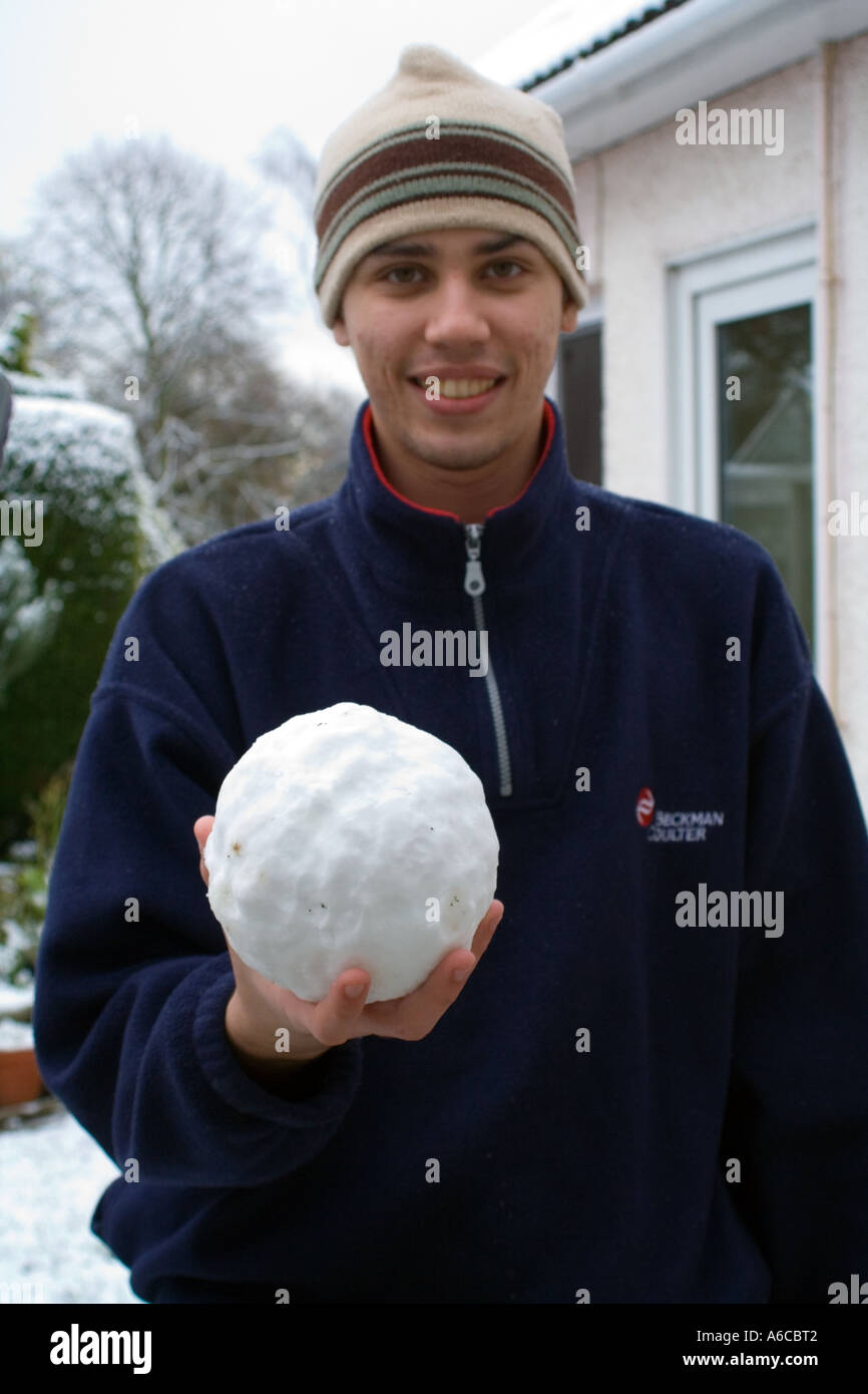 Un jeune adulte possédant un boule de neige Banque D'Images
