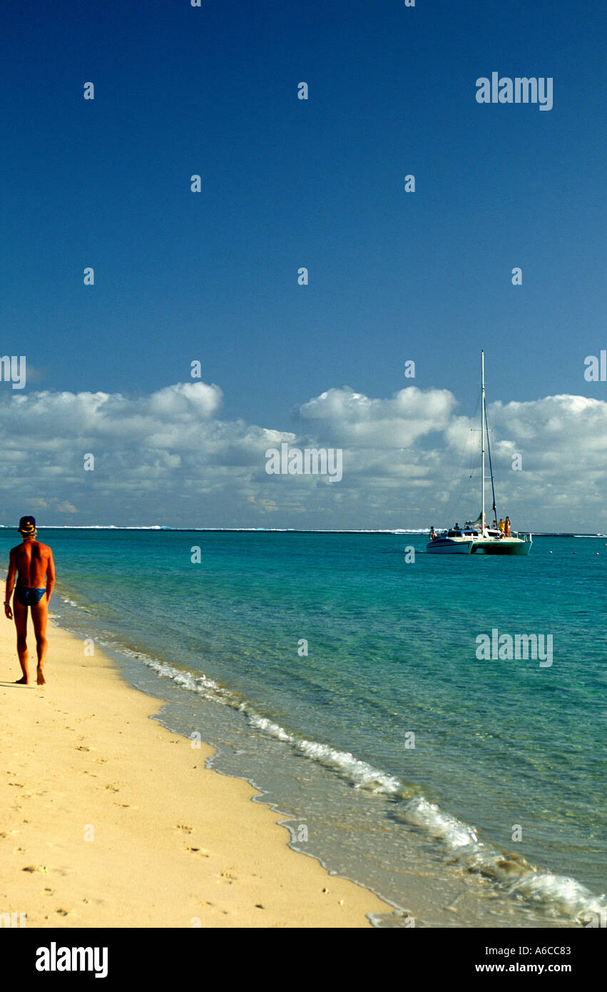 Homme marchant le long Beach Mauritius Catamaran avec la location à l'étranger Banque D'Images