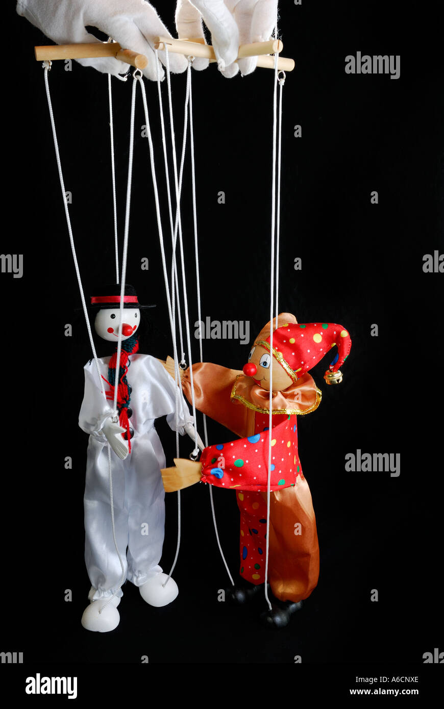 Marionnettes Clown à propos d'embrasser tenu par white gloved marionnettiste avec un fond noir Banque D'Images