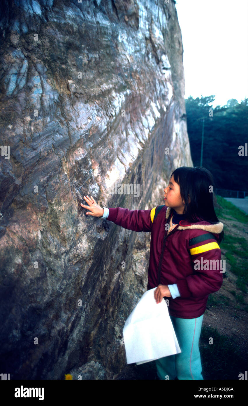 7822 sevan 7 ans, fille se sent exsposed rock surface lisse fait par un vieux problème Banque D'Images