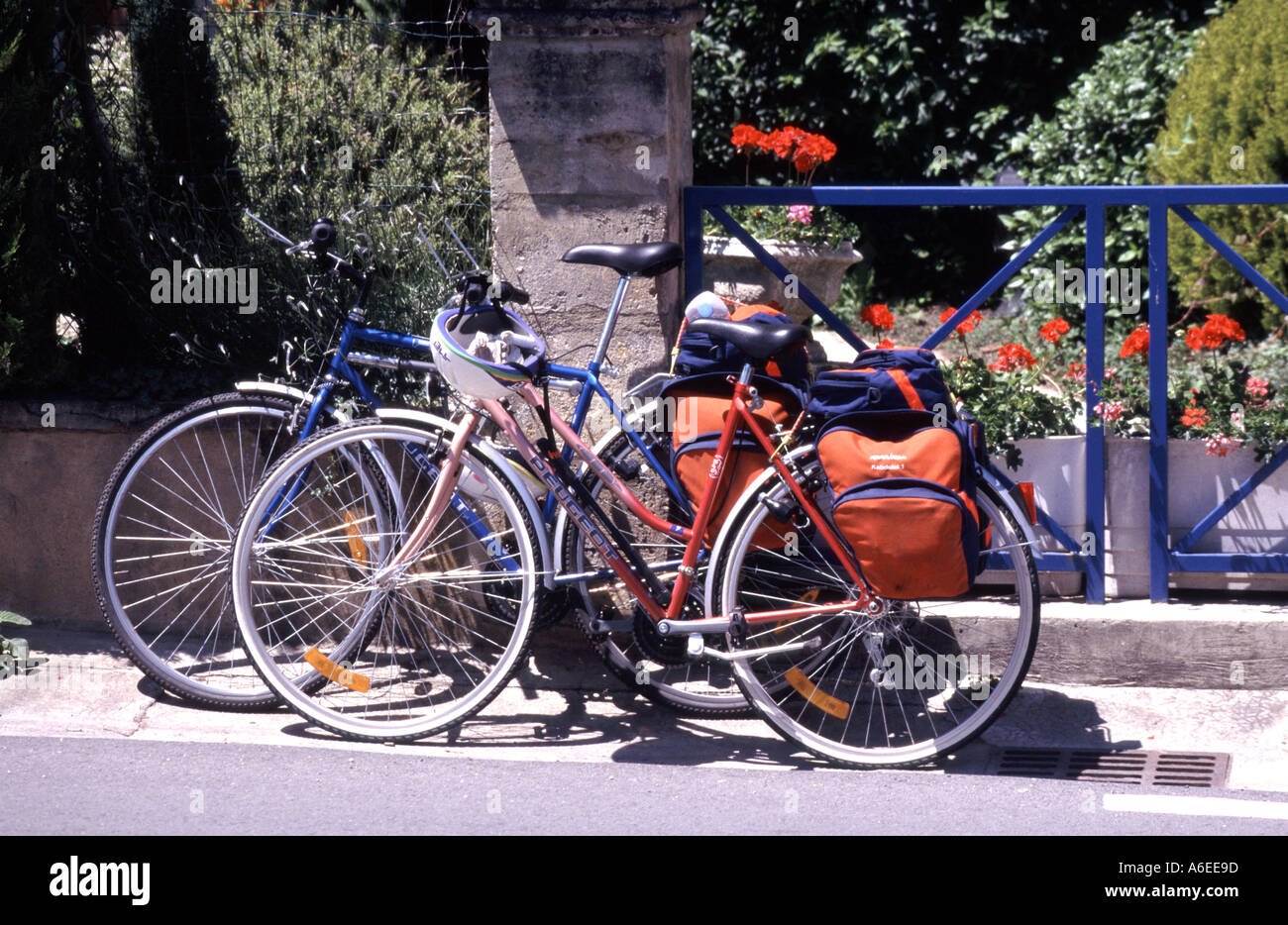 Vélos conçus pour une femme équipée de sacs de tourisme garés devant une auberge de jeunesse par une journée ensoleillée au Bugue Nouvelle-Aquitaine Dordogne France Banque D'Images