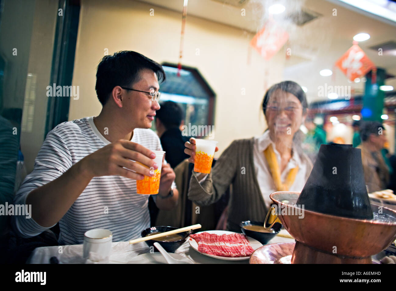 Jeune couple chinois CHINE Pékin toasts au repas de célébration potée mongole Banque D'Images