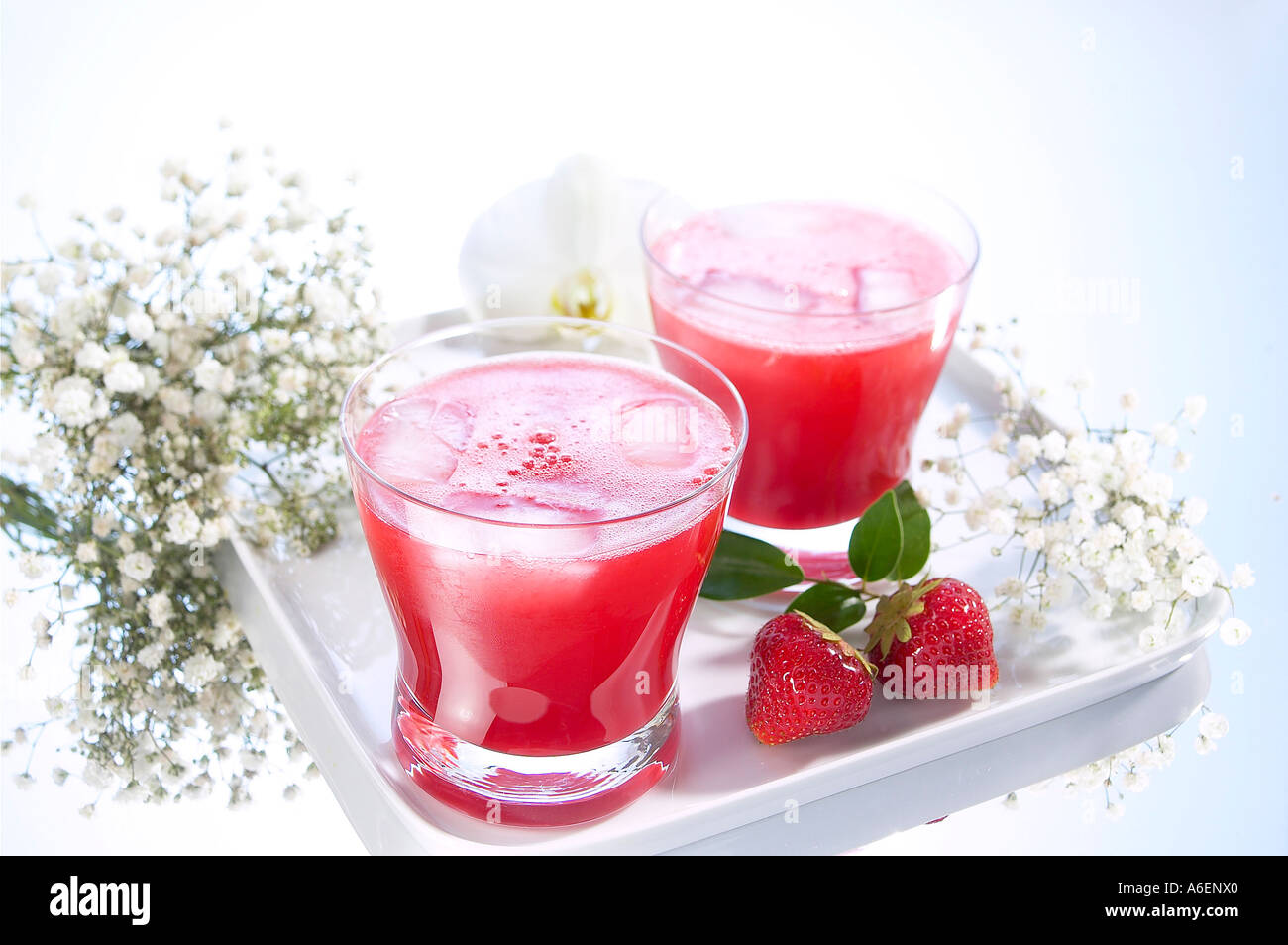 Deux Cocktailglasses sur petit plateau avec fraises et fleurs décoratives Banque D'Images