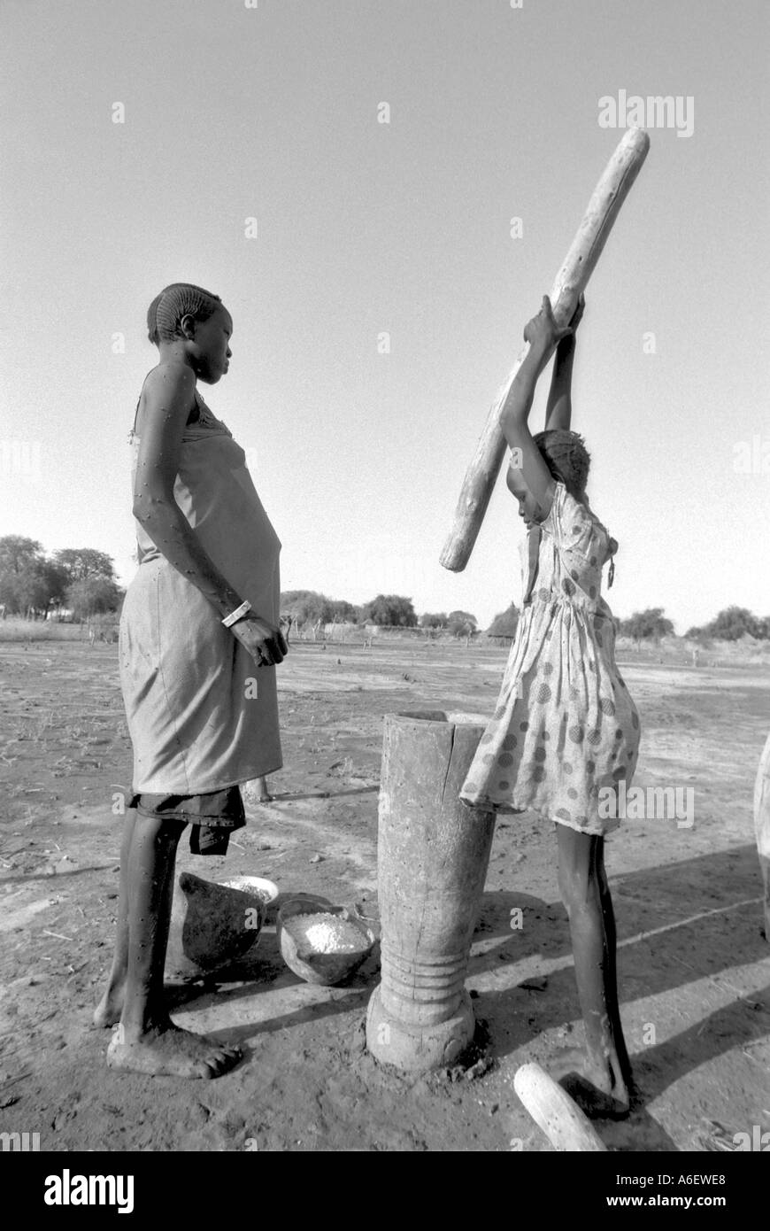 B/W d'une jeune fille qui apprend à livre du maïs à Bahr al Ghazal, Soudan Banque D'Images