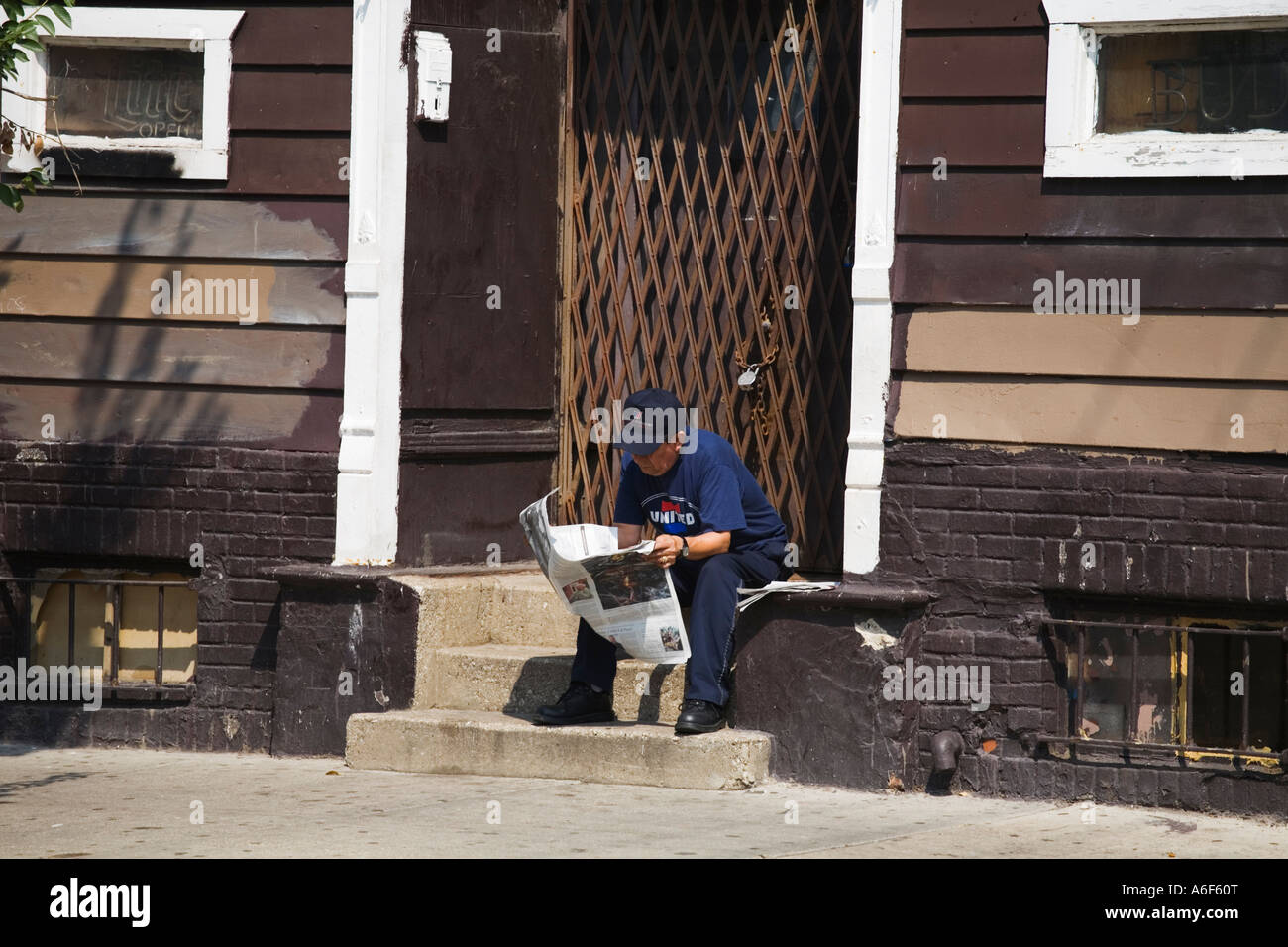 Chicago Illinois homme mexicain s'asseoir sur les marches et lire sur quartier Pilsen journal près de côté sud Banque D'Images