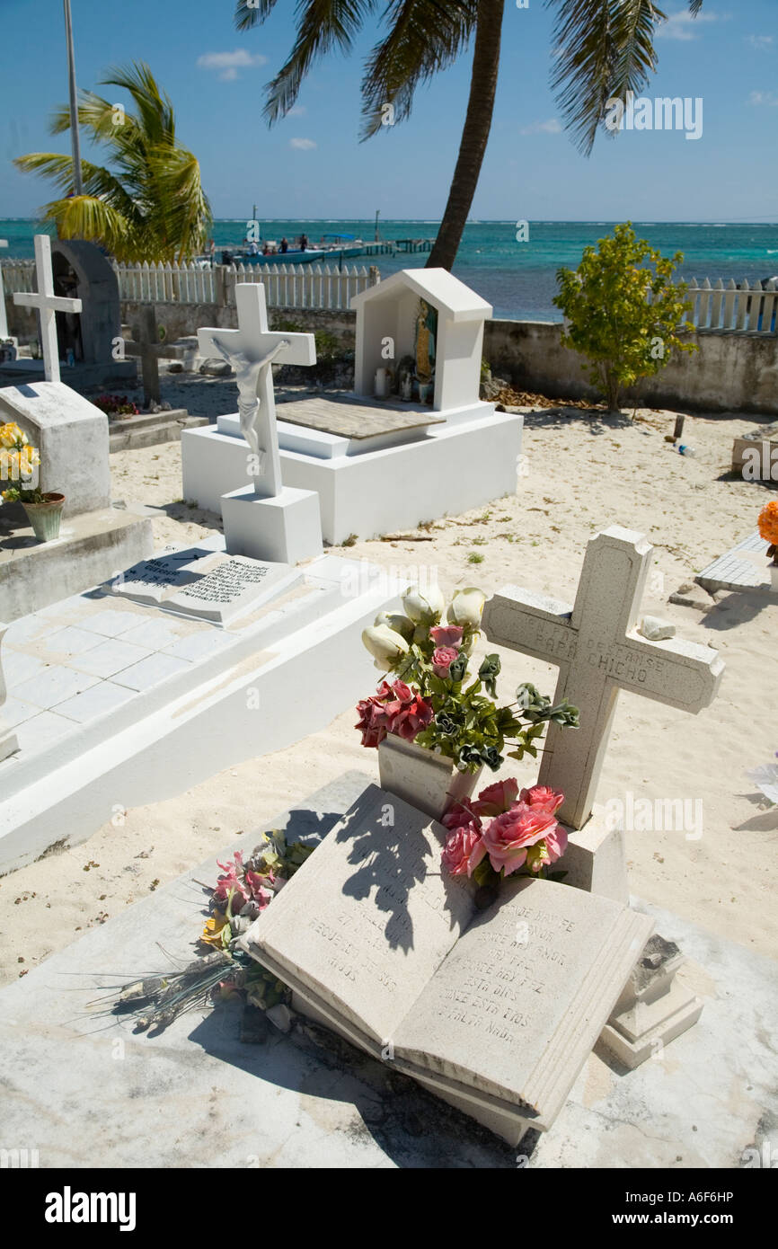 Les marqueurs d'Ambergris Caye BELIZE et fleurs en cimetière près de la côte des Caraïbes palmier sable clôture blanche Banque D'Images