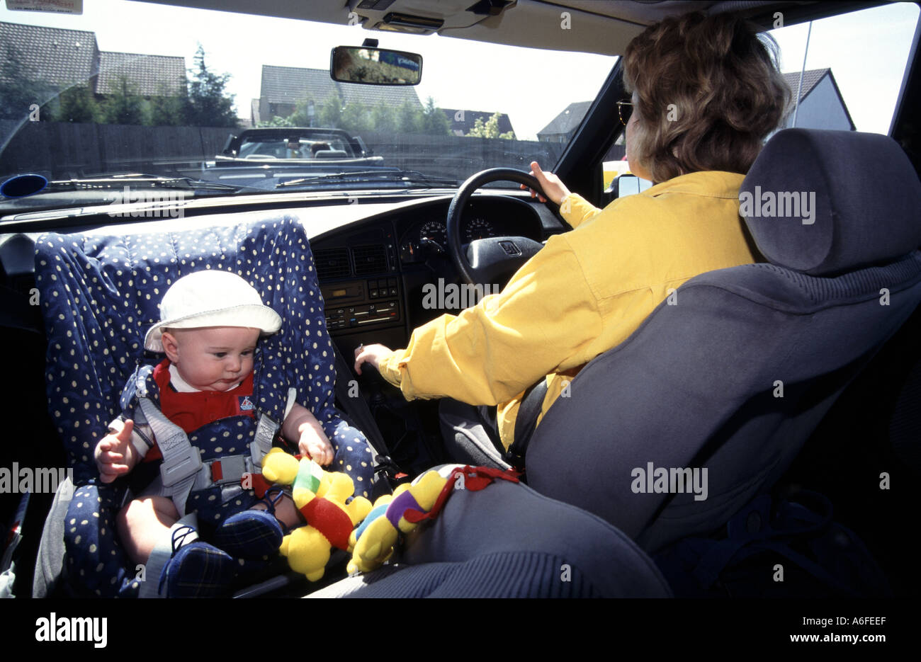 Siège de sécurité auto pour enfant orienté vers l'arrière tel qu'installé dans la vue d'archives historiques de 1996 du nouveau-né garçon voyageant dans la voiture de mères le long de la route achalandée Angleterre Royaume-Uni Banque D'Images