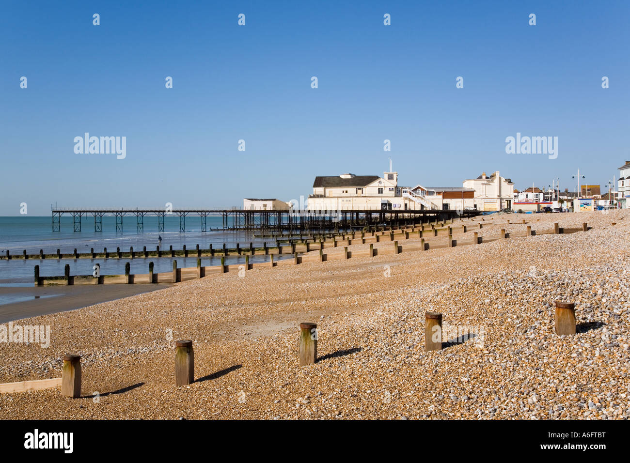 Plage de galets vide à marée basse, la mer brise-lames en bois et de l'embarcadère de postes hors saison. Littlehampton West Sussex England Royaume-Uni. Banque D'Images