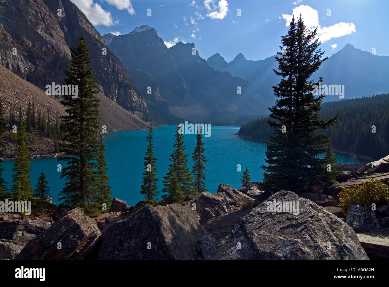 Les arbres en contre-jour et les rochers au bord du lac Moraine avec les Pics Wenkchemna en arrière-plan, la vallée des Dix-Pics, B Banque D'Images