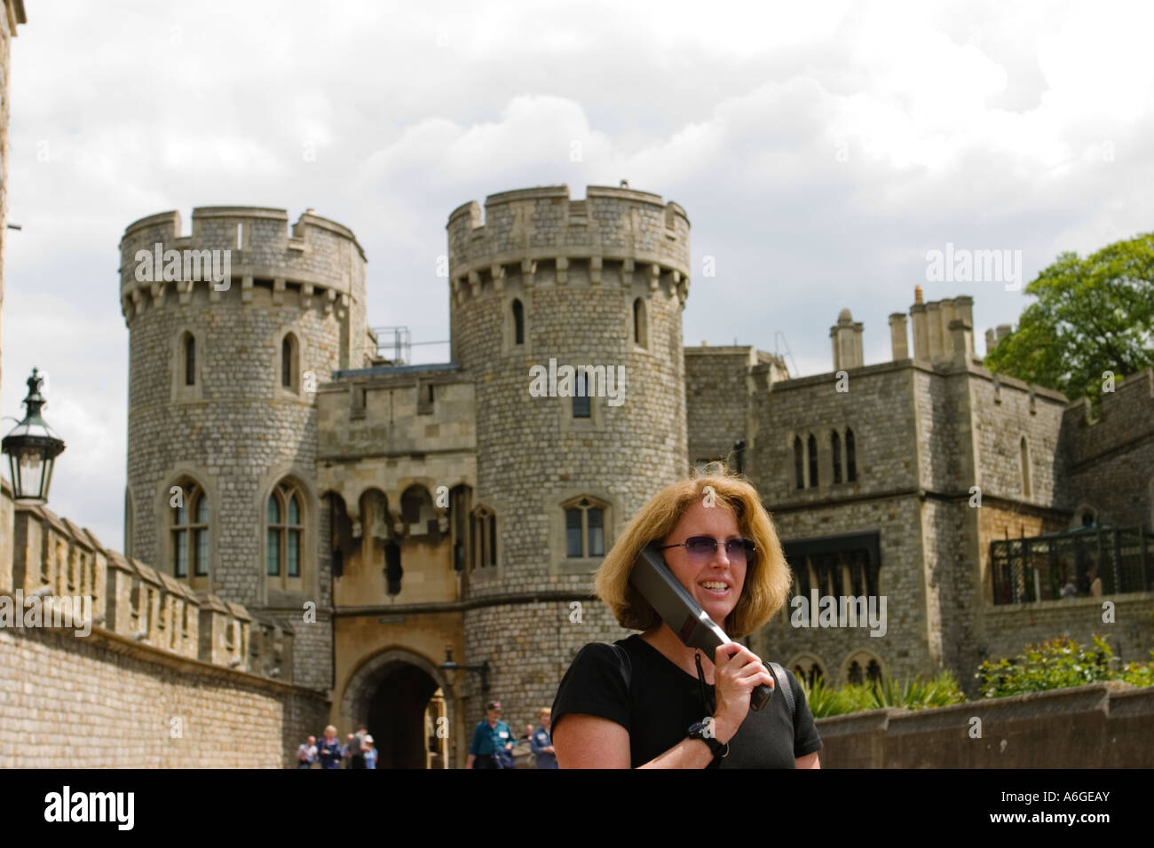 Angleterre Windsor touriste écouter de l'audio guide du château de Windsor et de tourelles, murs en arrière-plan Banque D'Images
