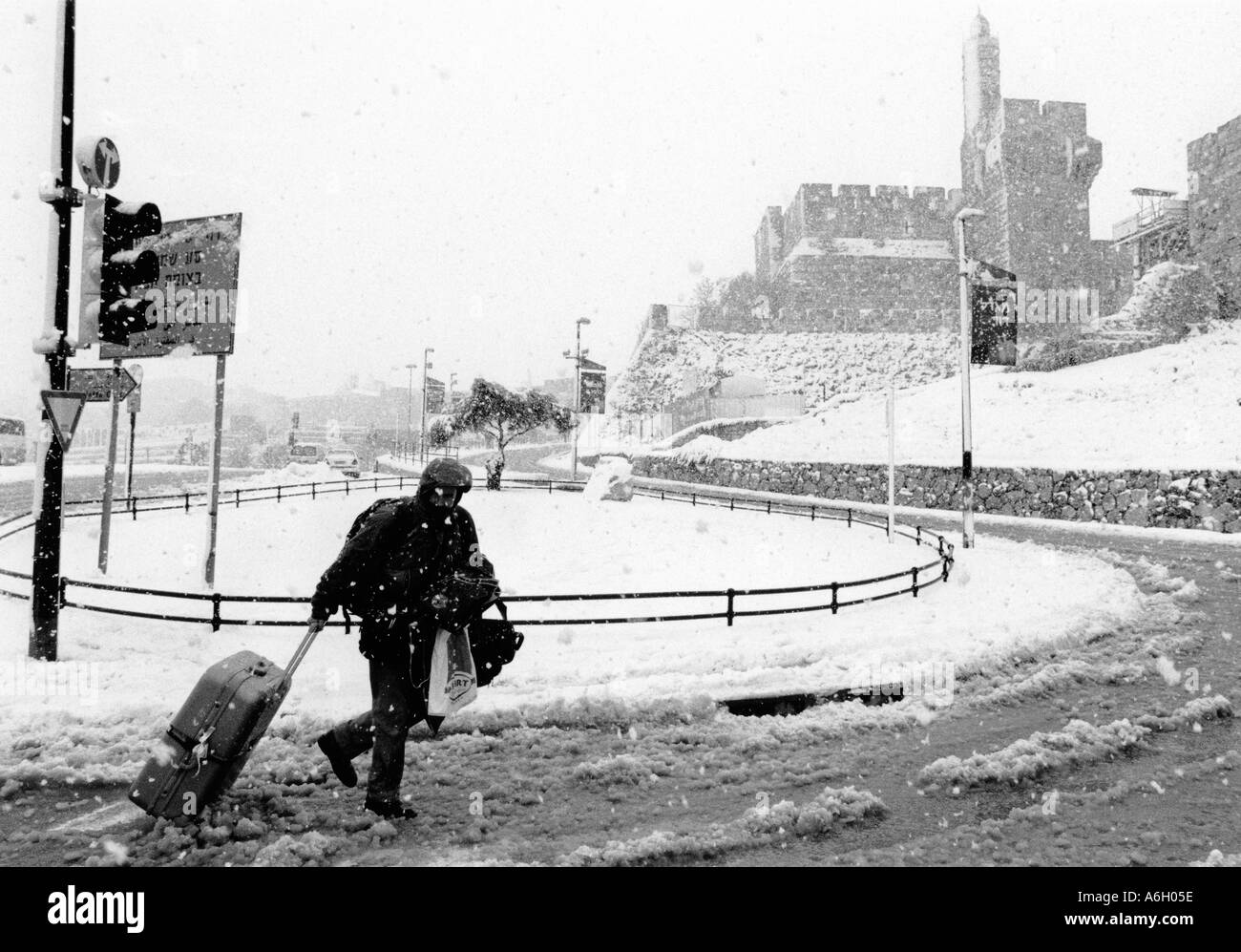 Israël Jérusalem près de Old City man towing sa valise sur la route menant à la porte de Jaffa Tour de David dans bckgd Banque D'Images
