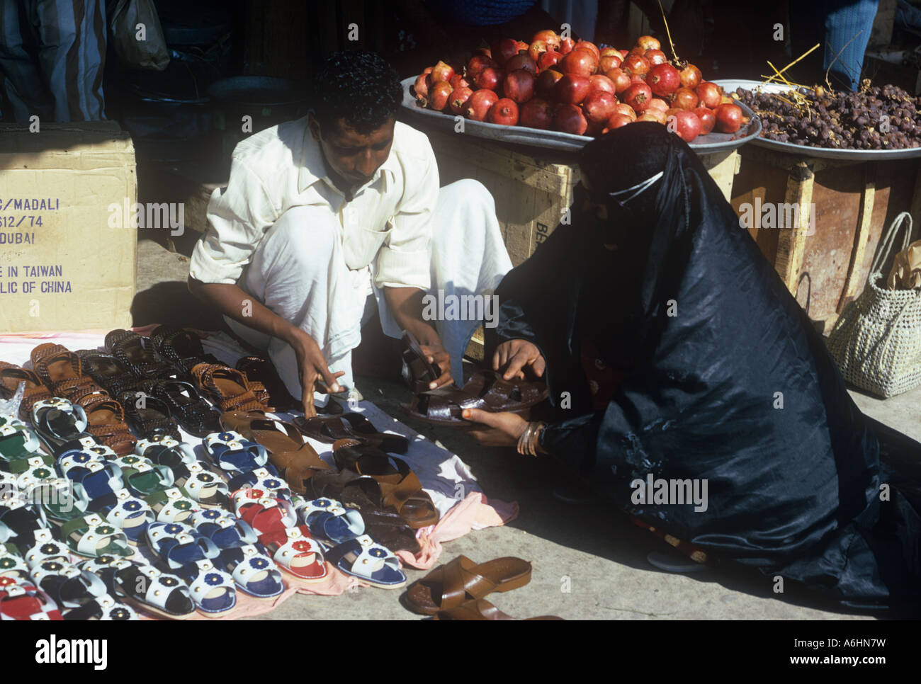 Arab woman shopping for shoes au le marché en plein air de Dubai 1975 Banque D'Images