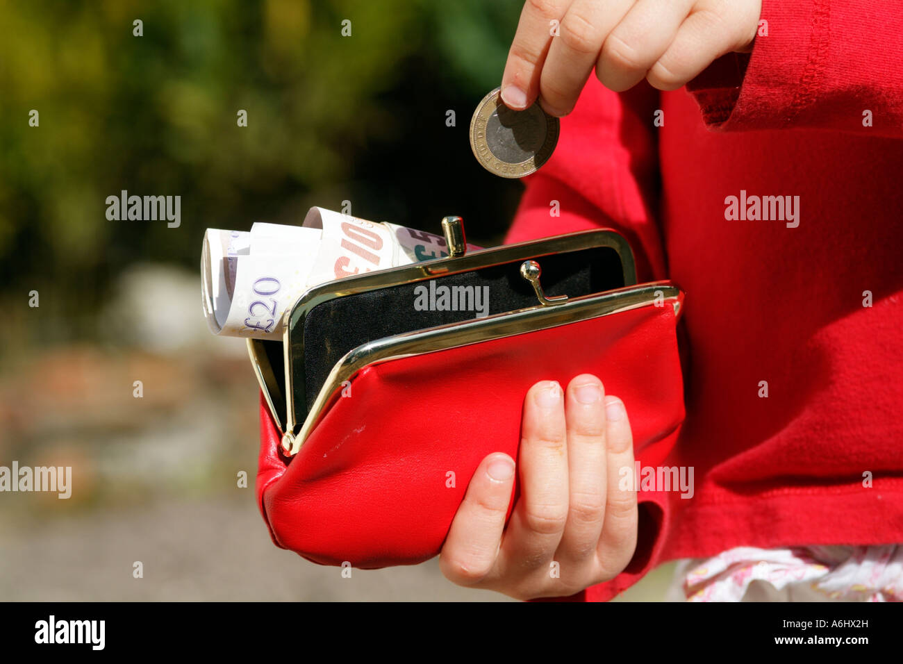 Enfant tenant bourse avec pocketmoney en comptant la main Banque D'Images