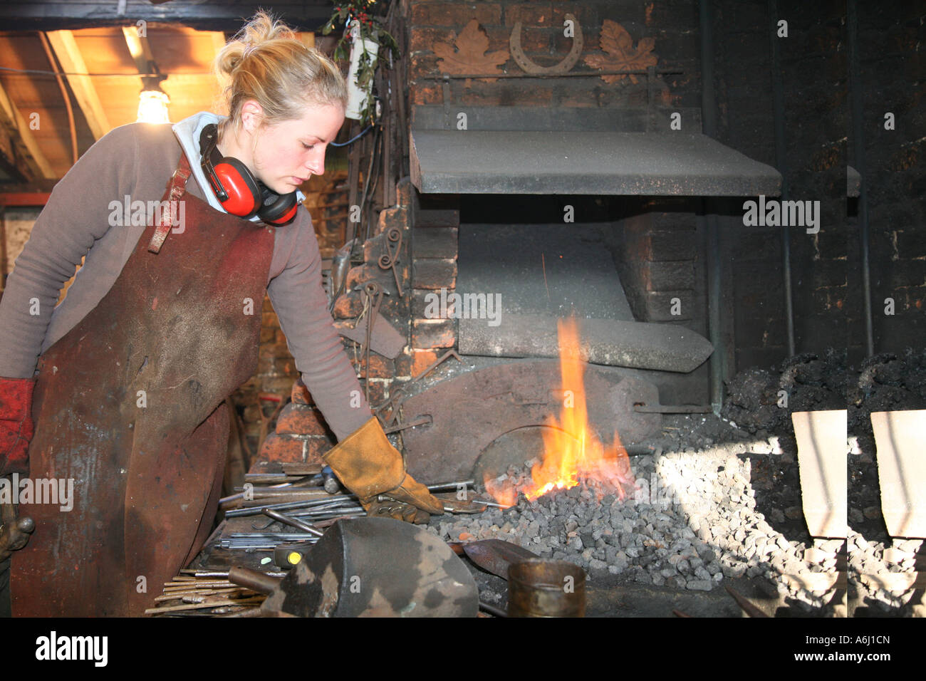 Une femme dans son travail de forgeron forge Banque D'Images