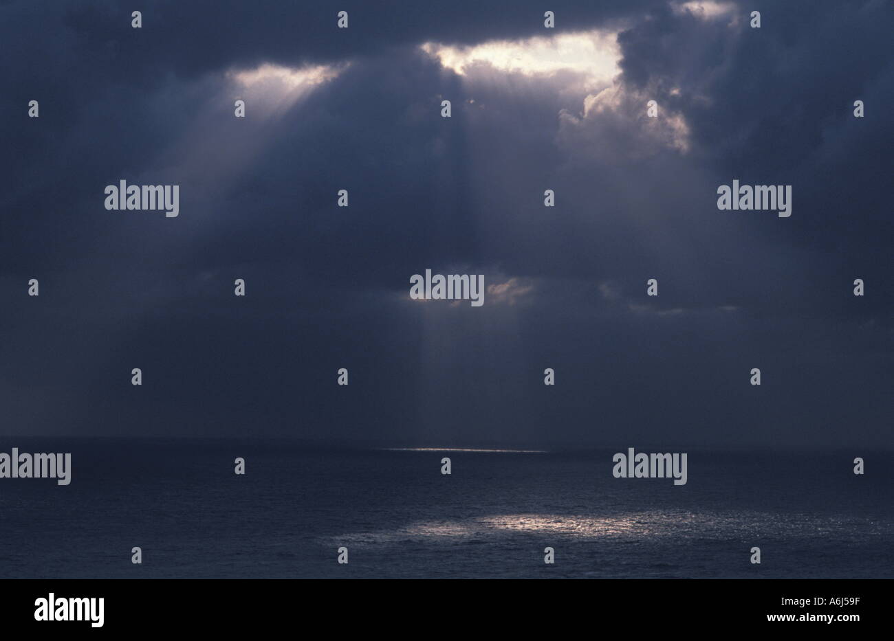 Lumière brillant à travers les nuages sur l'Océan Banque D'Images