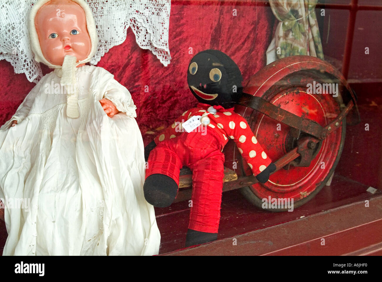 Vitrine de magasin antique affichant poupée vieux scooter et maintenant considéré comme poupée raciste golliwog Banque D'Images
