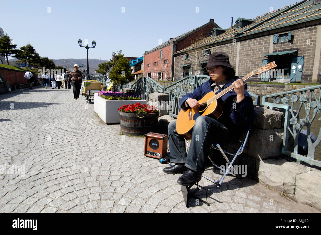 Musicien ambulant qui joue de la guitare à côté de fameux canal dans Otaru Japon 2005 Banque D'Images