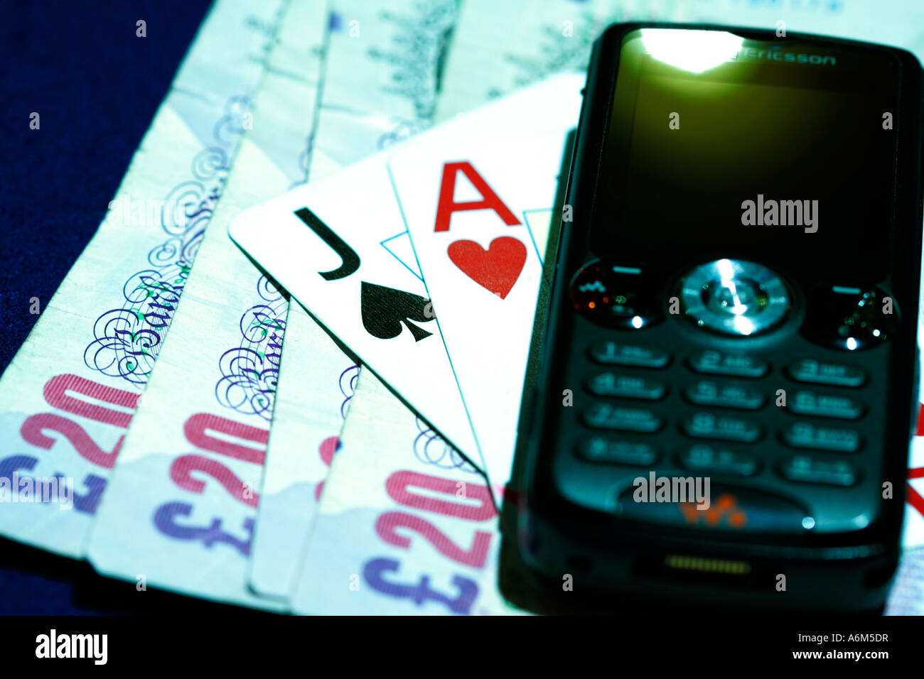Close up d'un casino cartes à jouer de l'argent téléphone mobile ace livre Banque D'Images