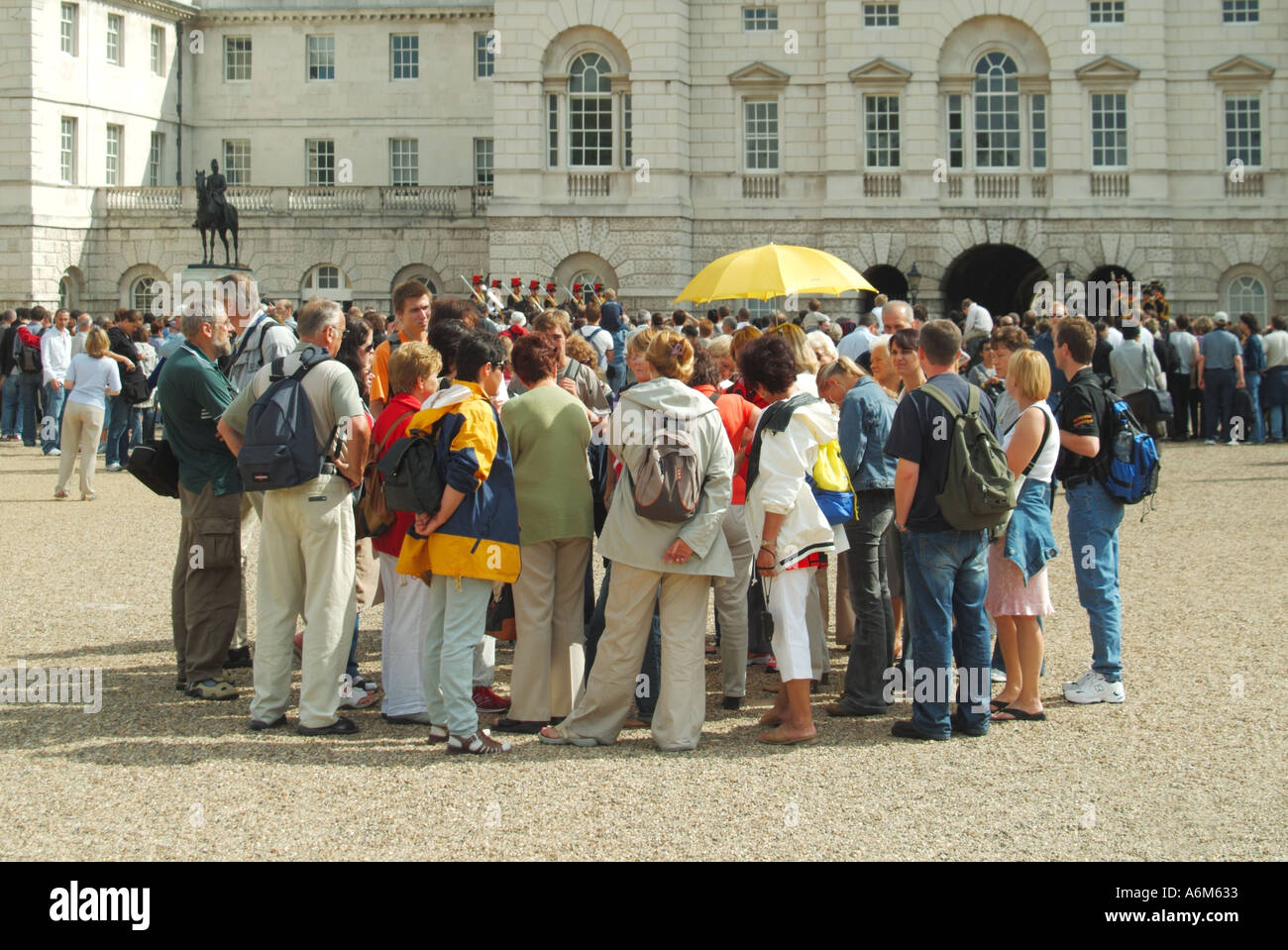 Les gardes de cheval défilent les touristes regardant changer la cérémonie de garde guide jaune parapluie groupe de personnes occupé événement Westminster Londres Angleterre Royaume-Uni Banque D'Images