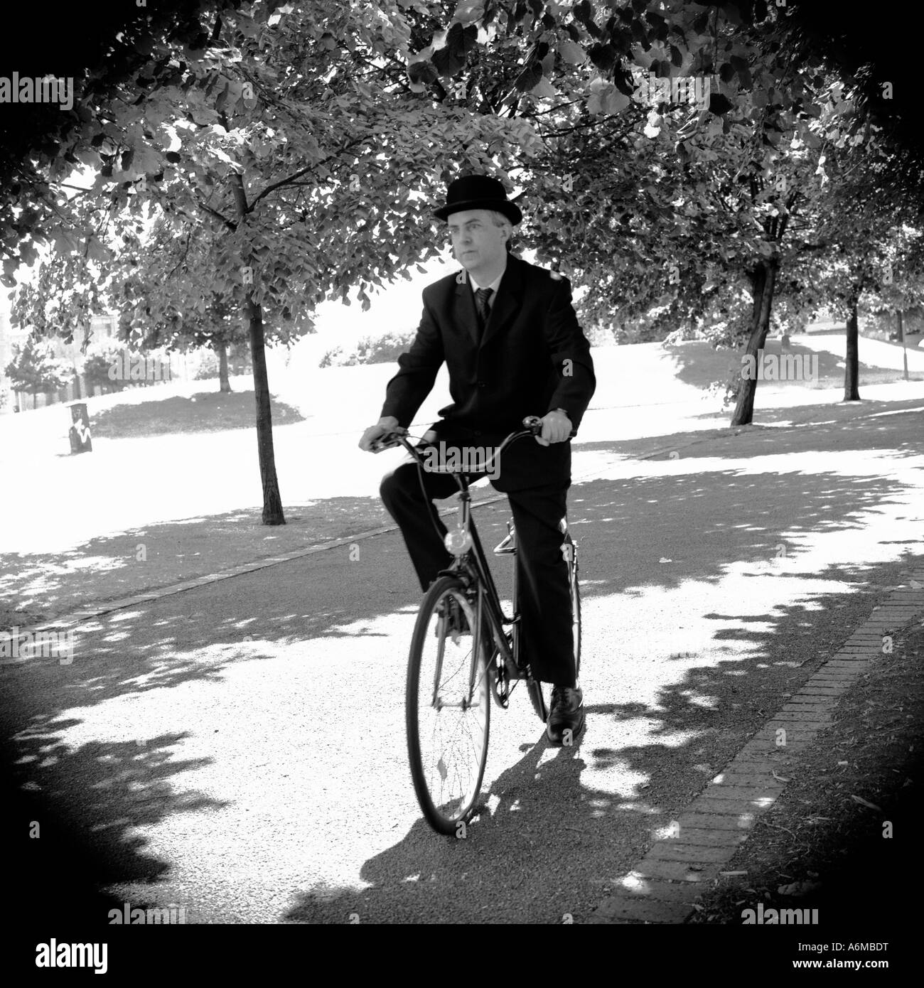 Anglais à vélo sur vélo portant chapeau melon et costume traditionnel Banque D'Images