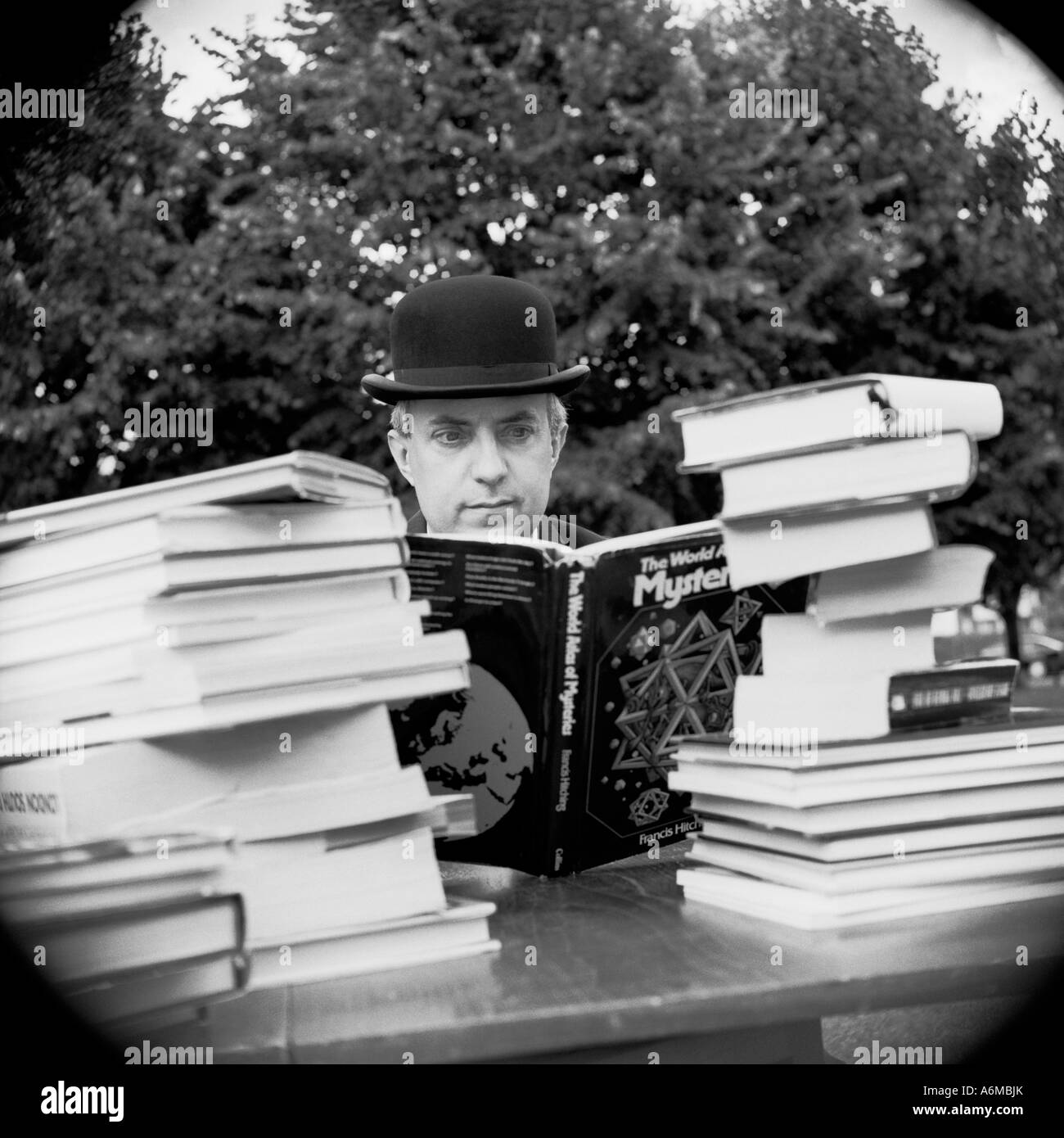 L'homme à chapeau melon la lecture de l'Atlas du monde de mystères Banque D'Images