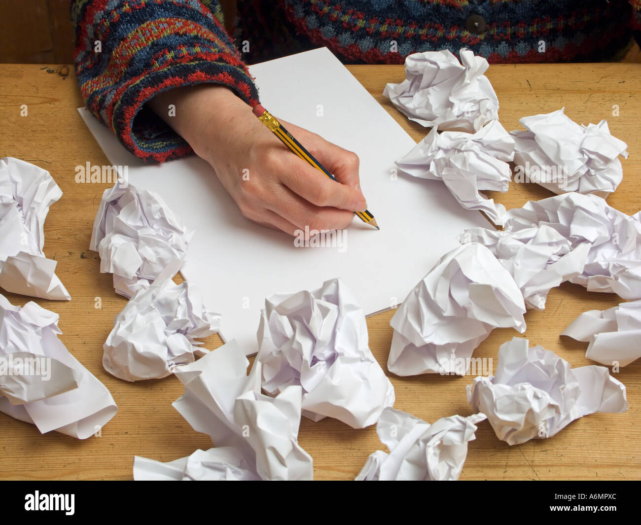 Quelqu'un avec des écrivains bloquer la tentative d'écriture sur une feuille de papier vierge entourée par de précédents a rejeté les tentatives Banque D'Images